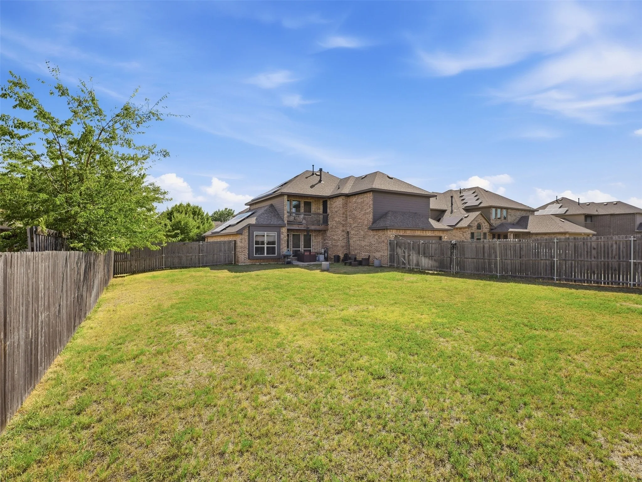 Expansive grass lawn bordered by a wood fence