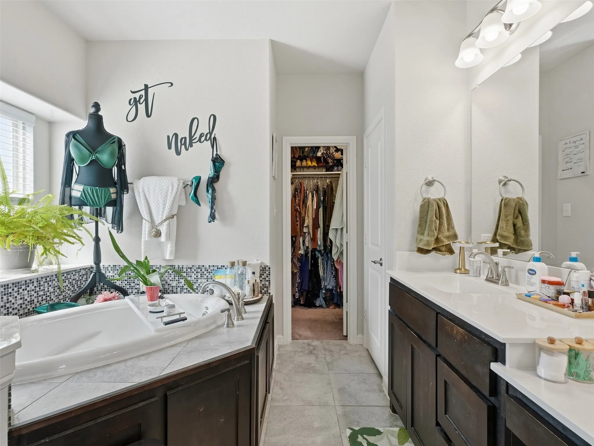 Dual vanity with undermount sinks, white countertops, and dark wood cabinetry