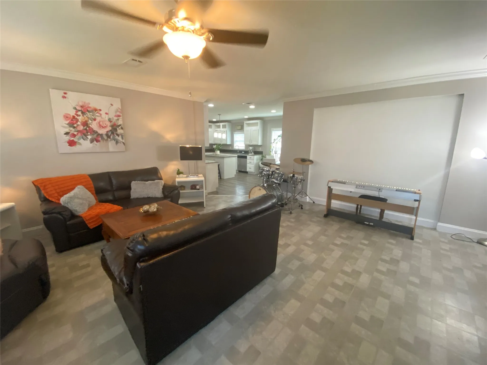 Living room featuring ornamental molding and ceiling fan