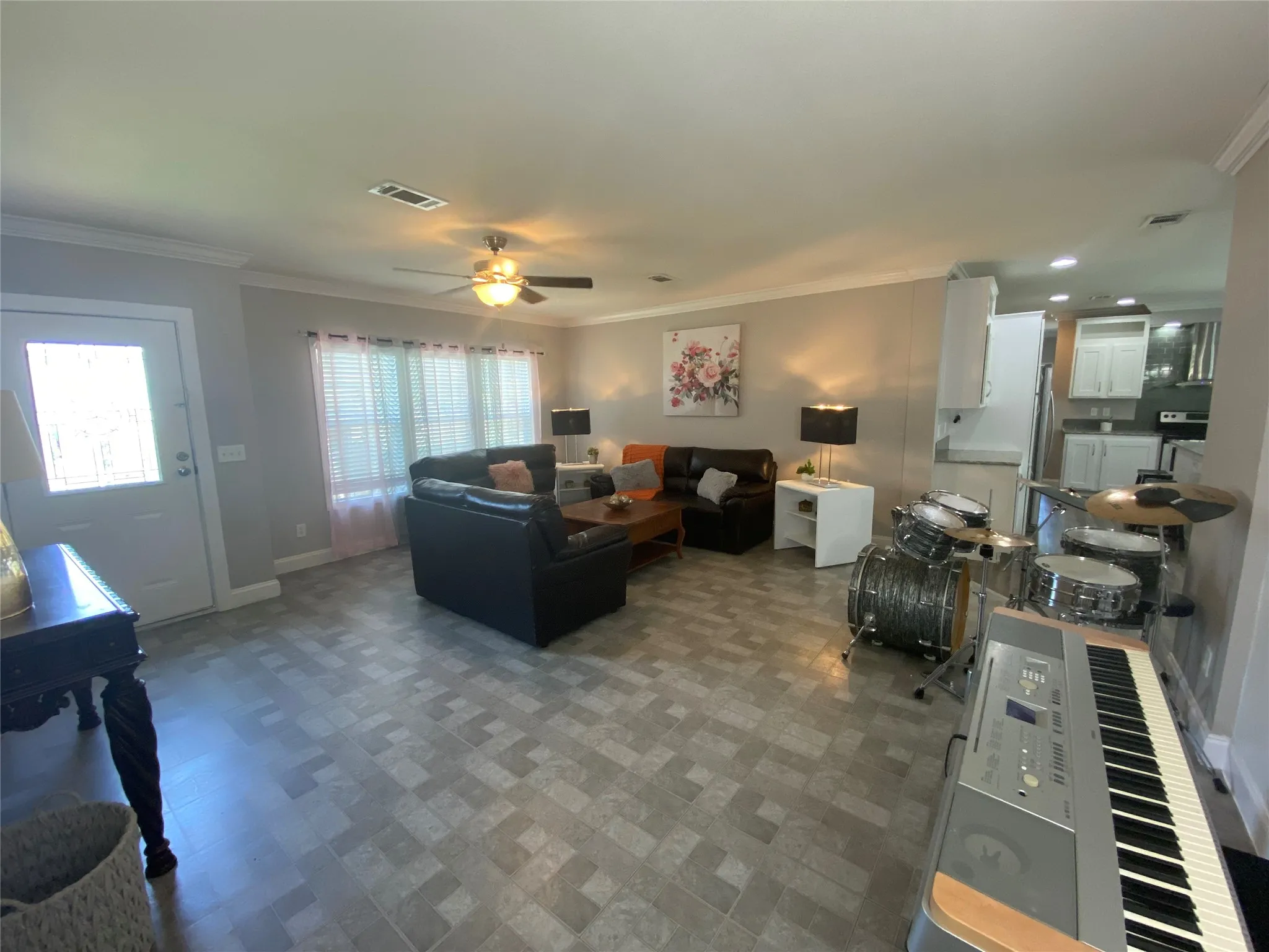 Living area featuring crown molding and ceiling fan