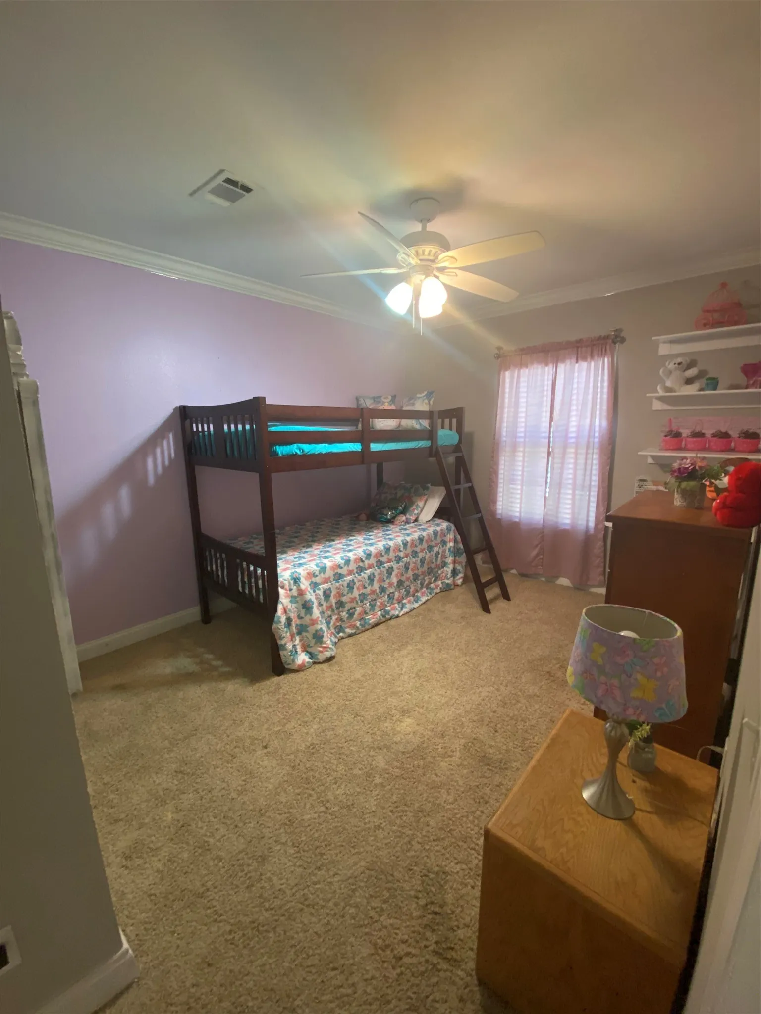 Bedroom with crown molding, light colored carpet, and ceiling fan