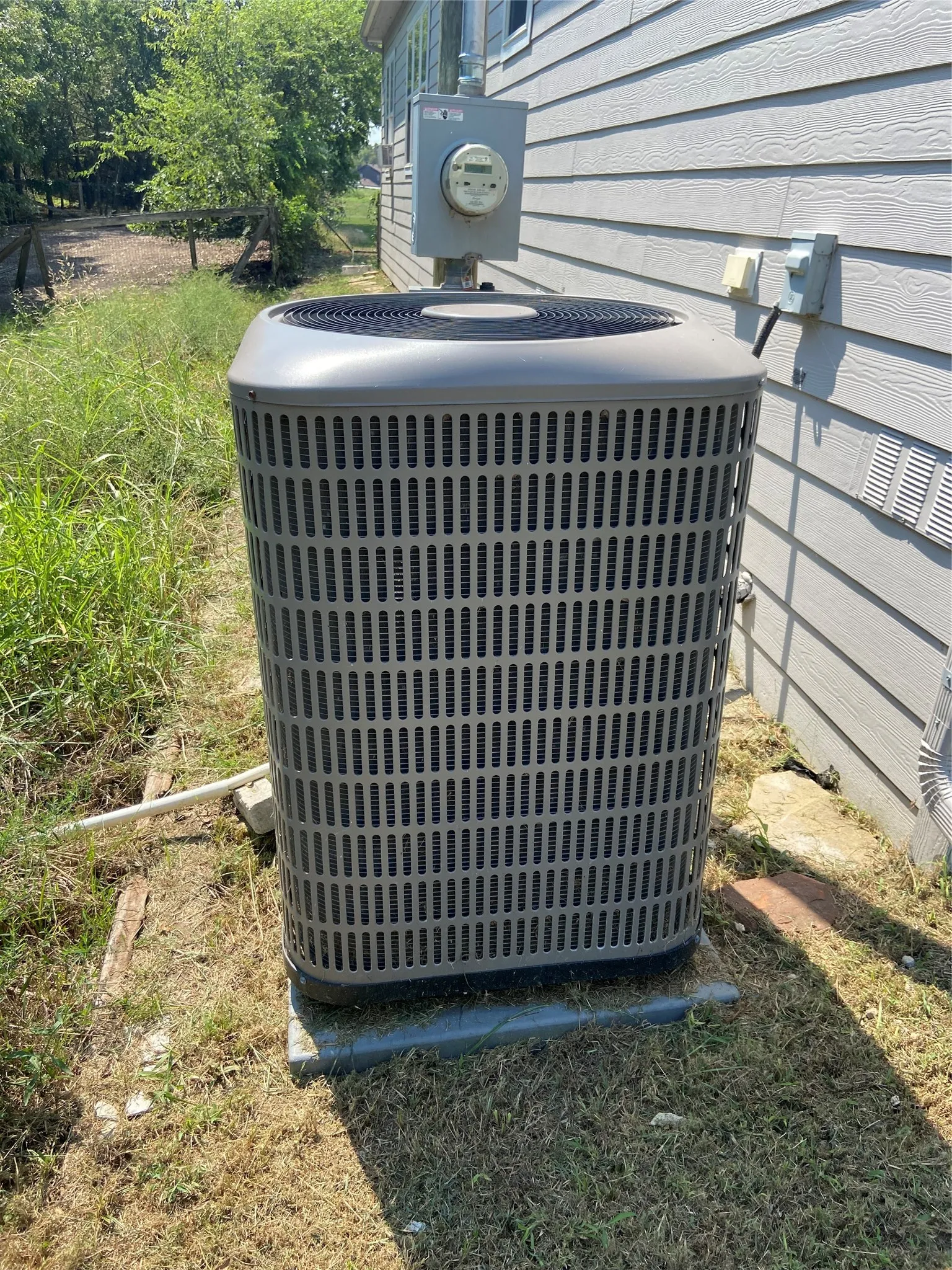 Exterior view of a central AC unit and electric meter