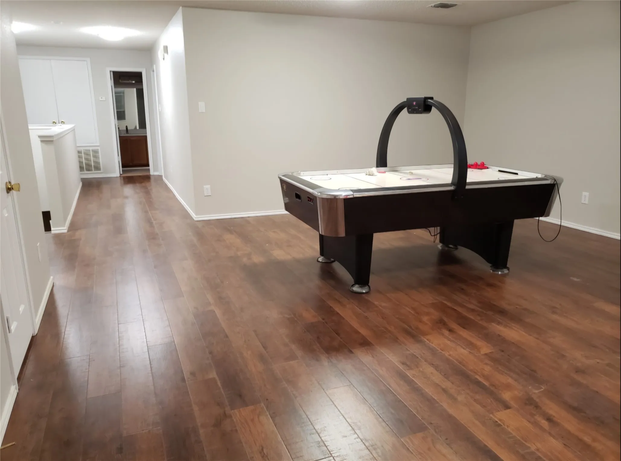 Wood-finish flooring throughout, light-toned wall paint, and recessed ceiling lighting