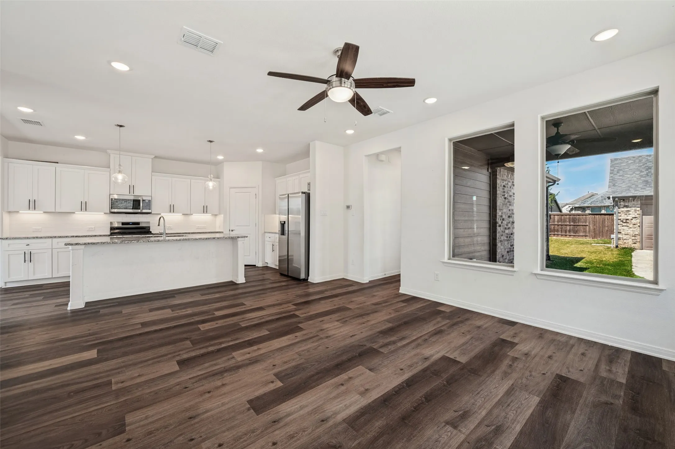 Open-concept living area featuring wood-finish flooring, recessed lighting, and a ceiling fan