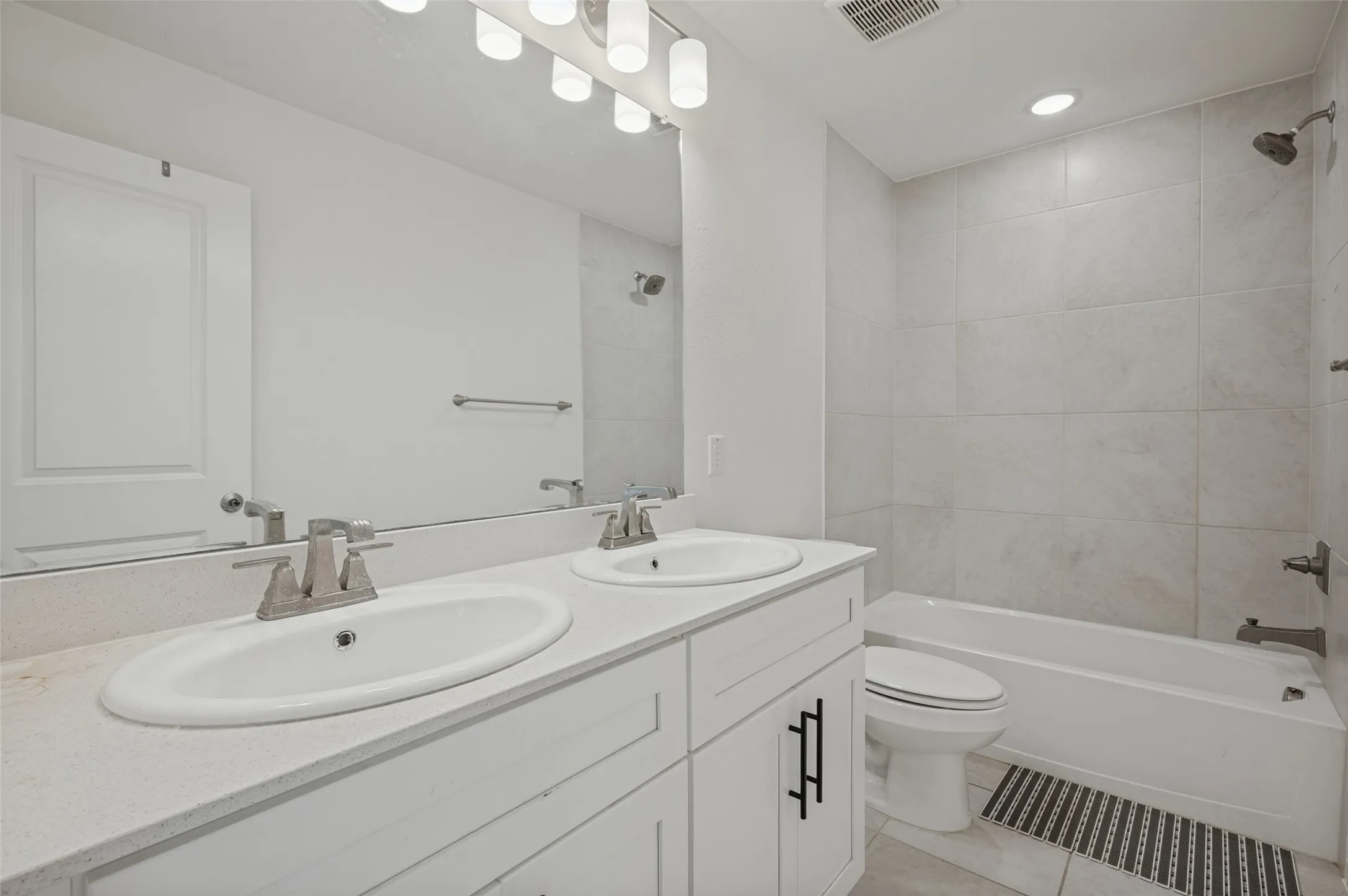 Double vanity with light-toned countertop, dual undermount sinks, and brushed nickel faucets