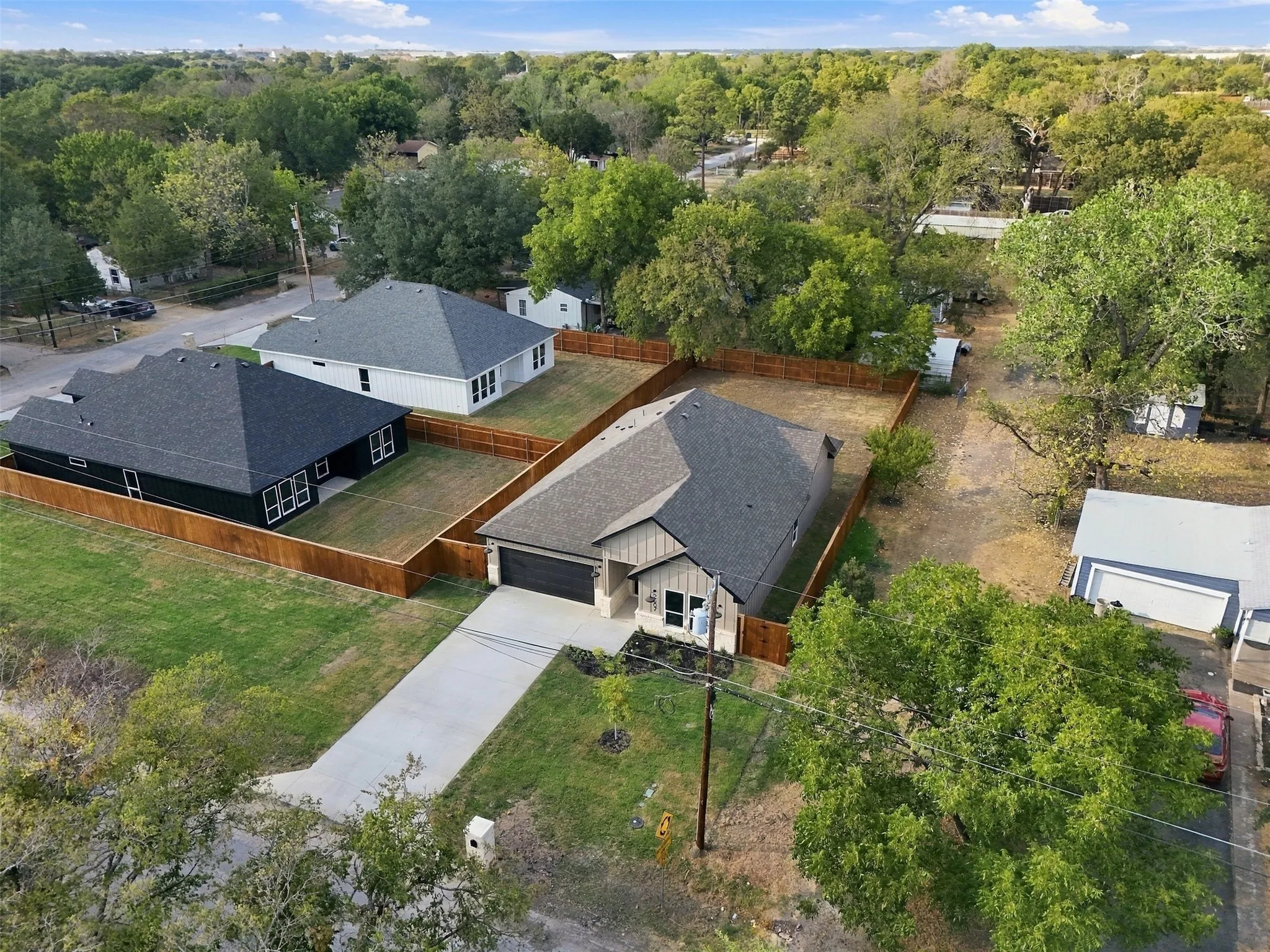 Fenced property with a neutral exterior, dark roof, and an attached garage