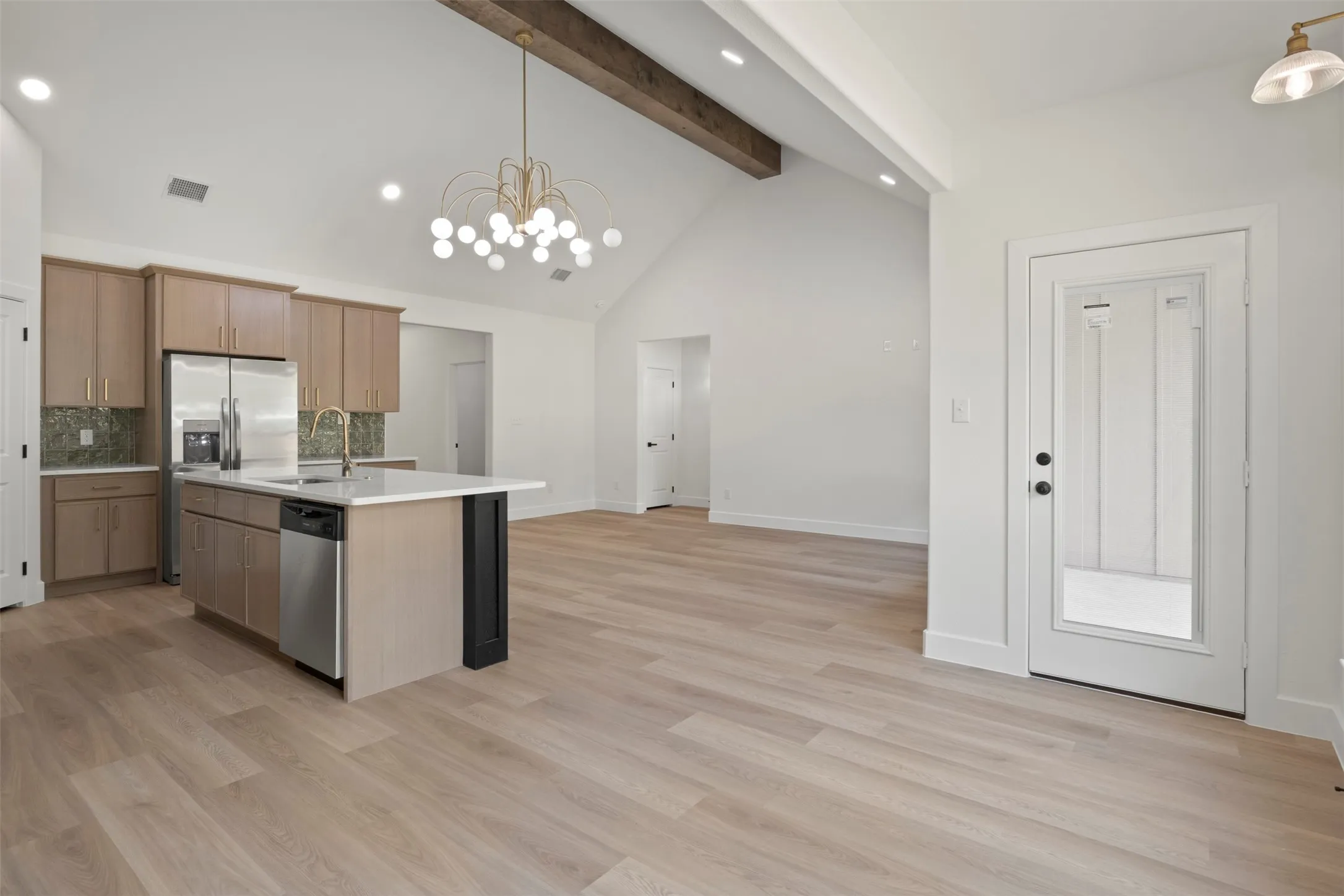 Vaulted ceiling with exposed wood beam and chandelier