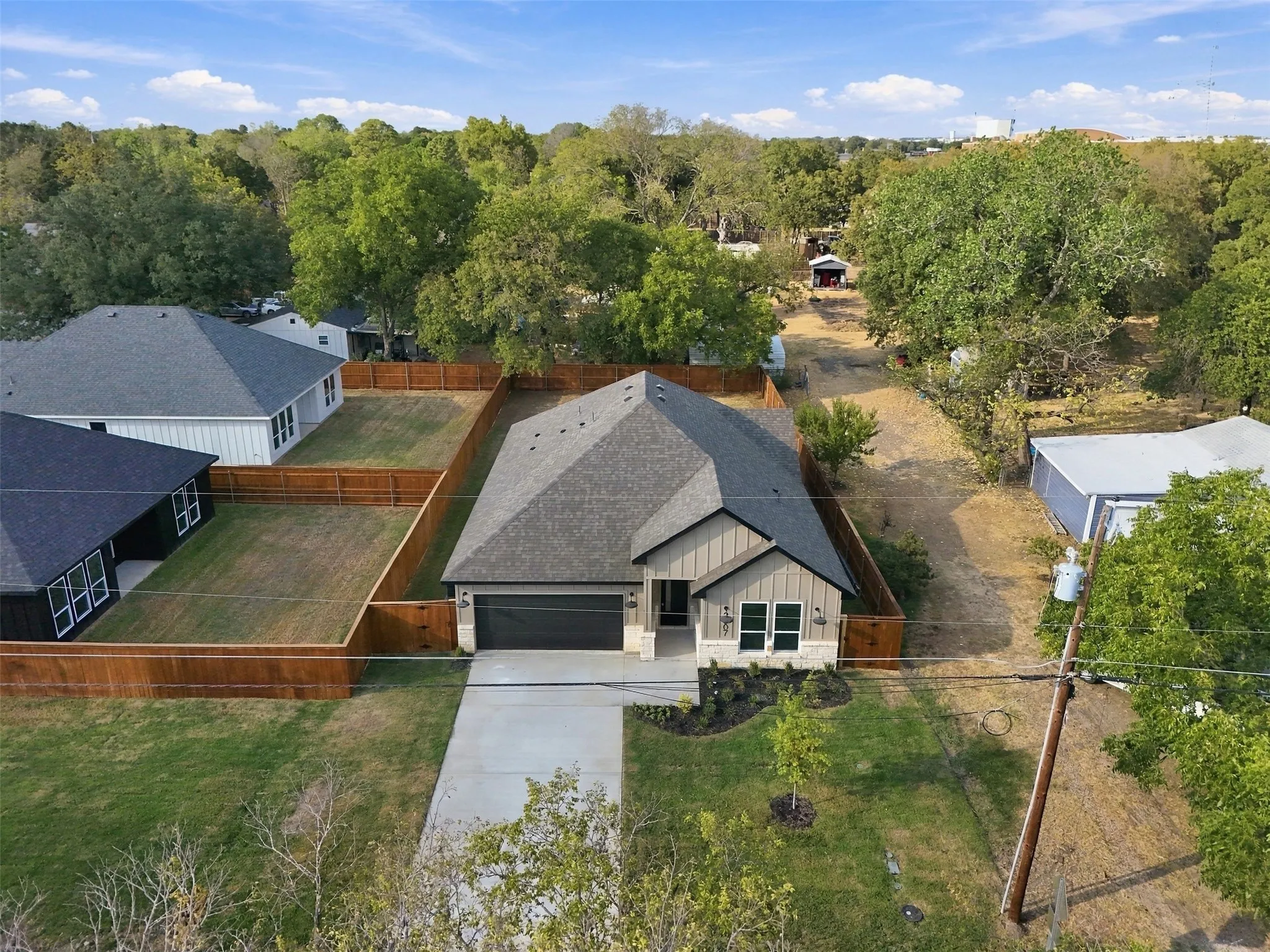Contemporary exterior with a dark shingle roof, attached garage, and light-toned siding