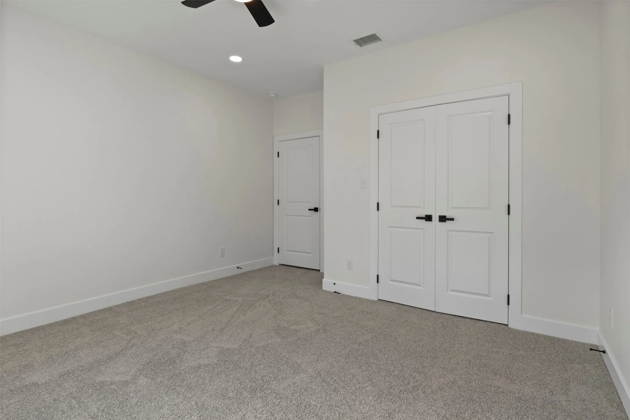 Neutral-toned carpeting, white walls, and white trim