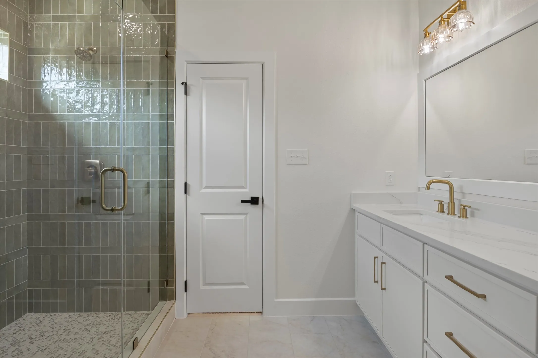 Frameless glass shower enclosure with gray vertical tile