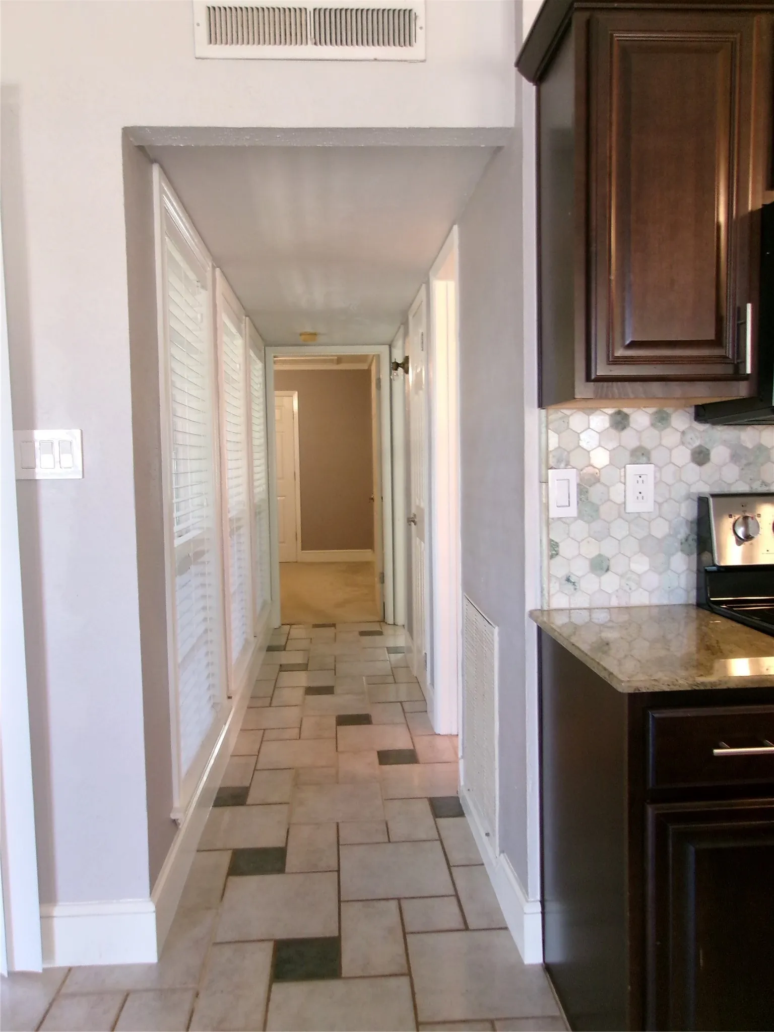 Hallway featuring patterned tile flooring