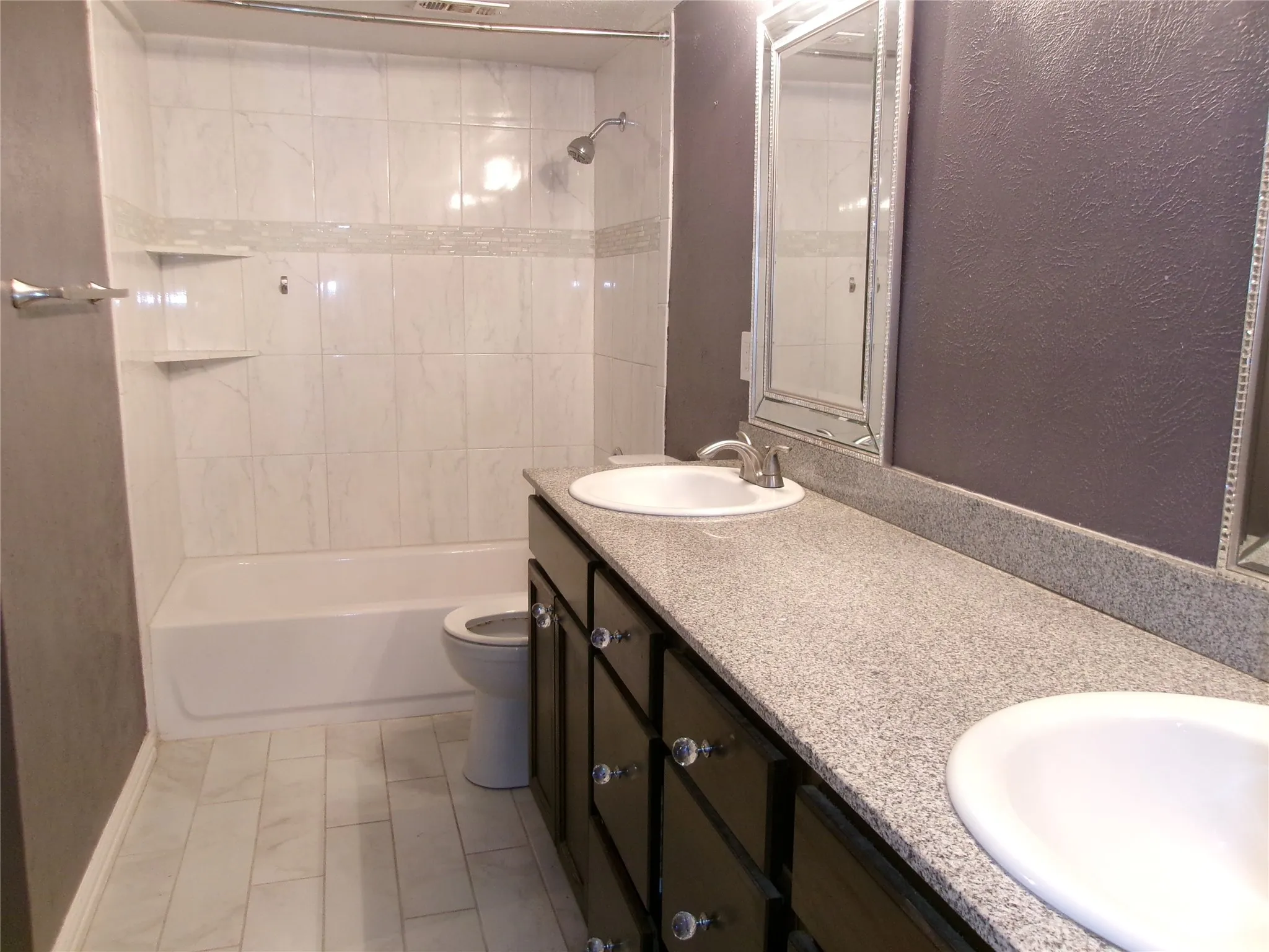 Dual vanity with integrated sinks, dark wood-finish cabinetry, and light-toned speckled countertops