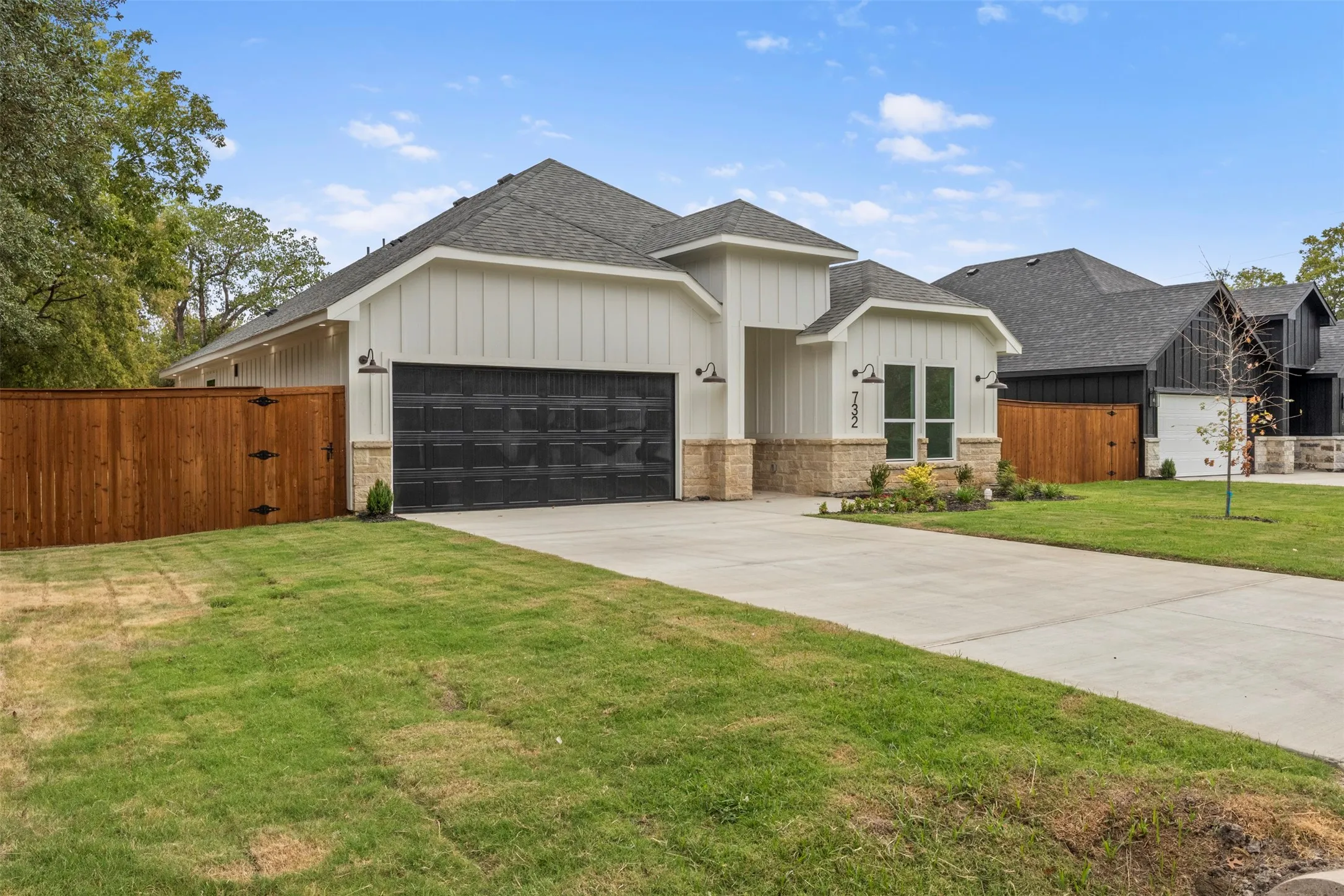 Contemporary facade with vertical siding, stone accents, and a dark garage door
