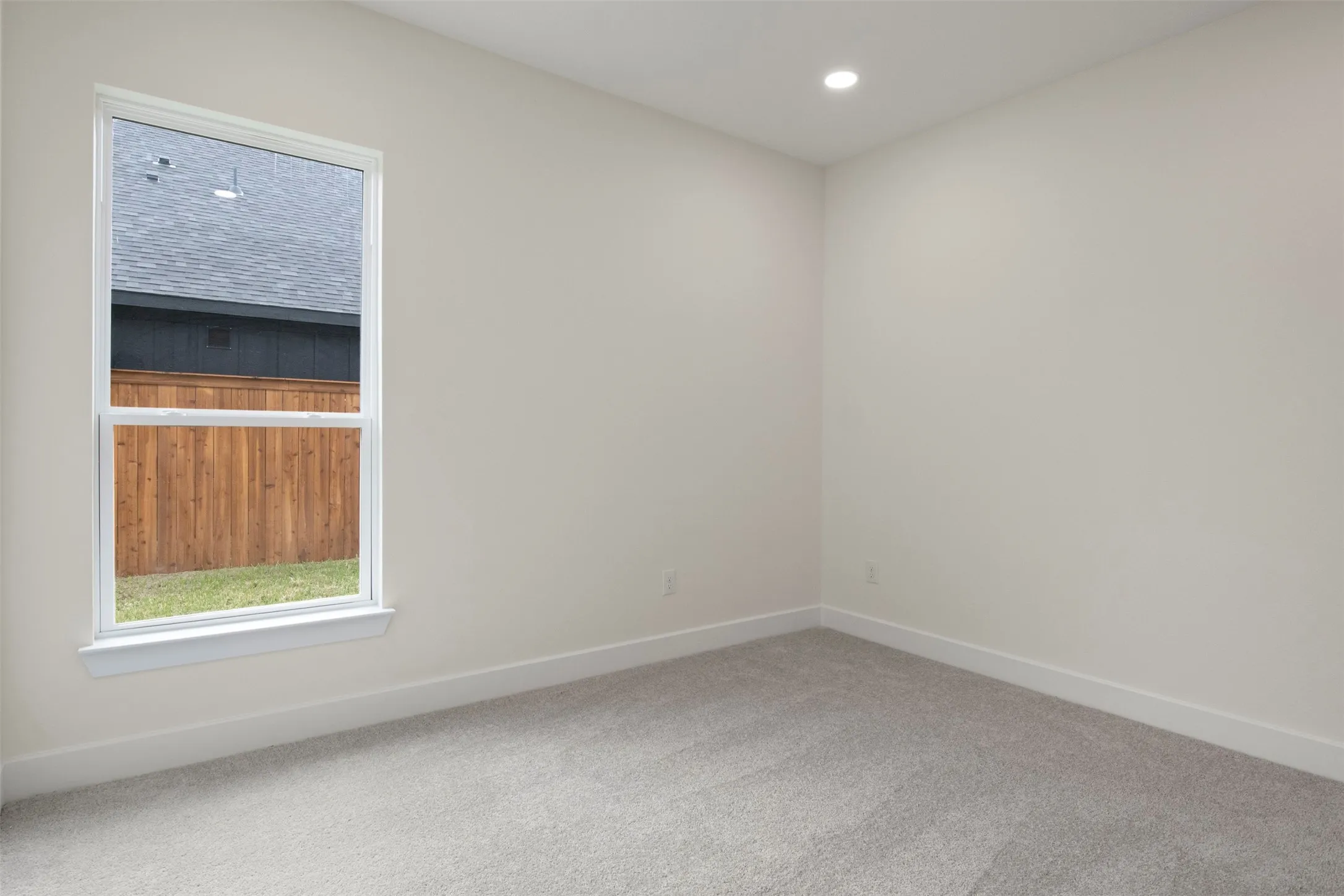 Recessed lighting, plush carpet flooring, white trim, and a double-hung window