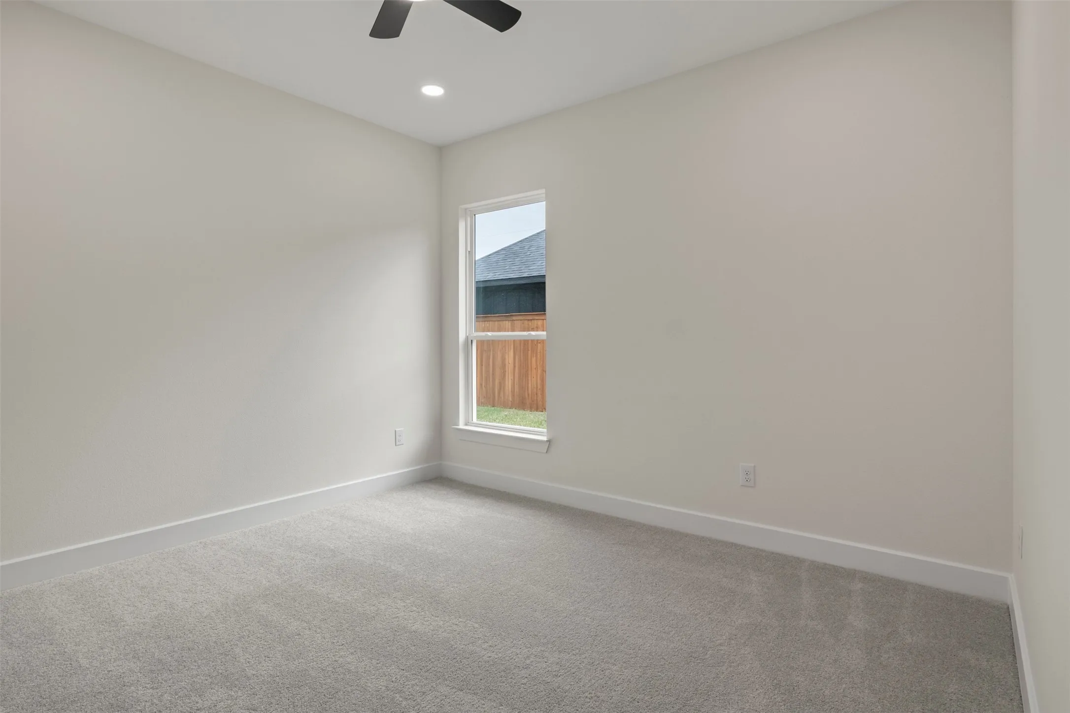 Neutral wall tones, gray carpeting, recessed lighting, and a ceiling fan