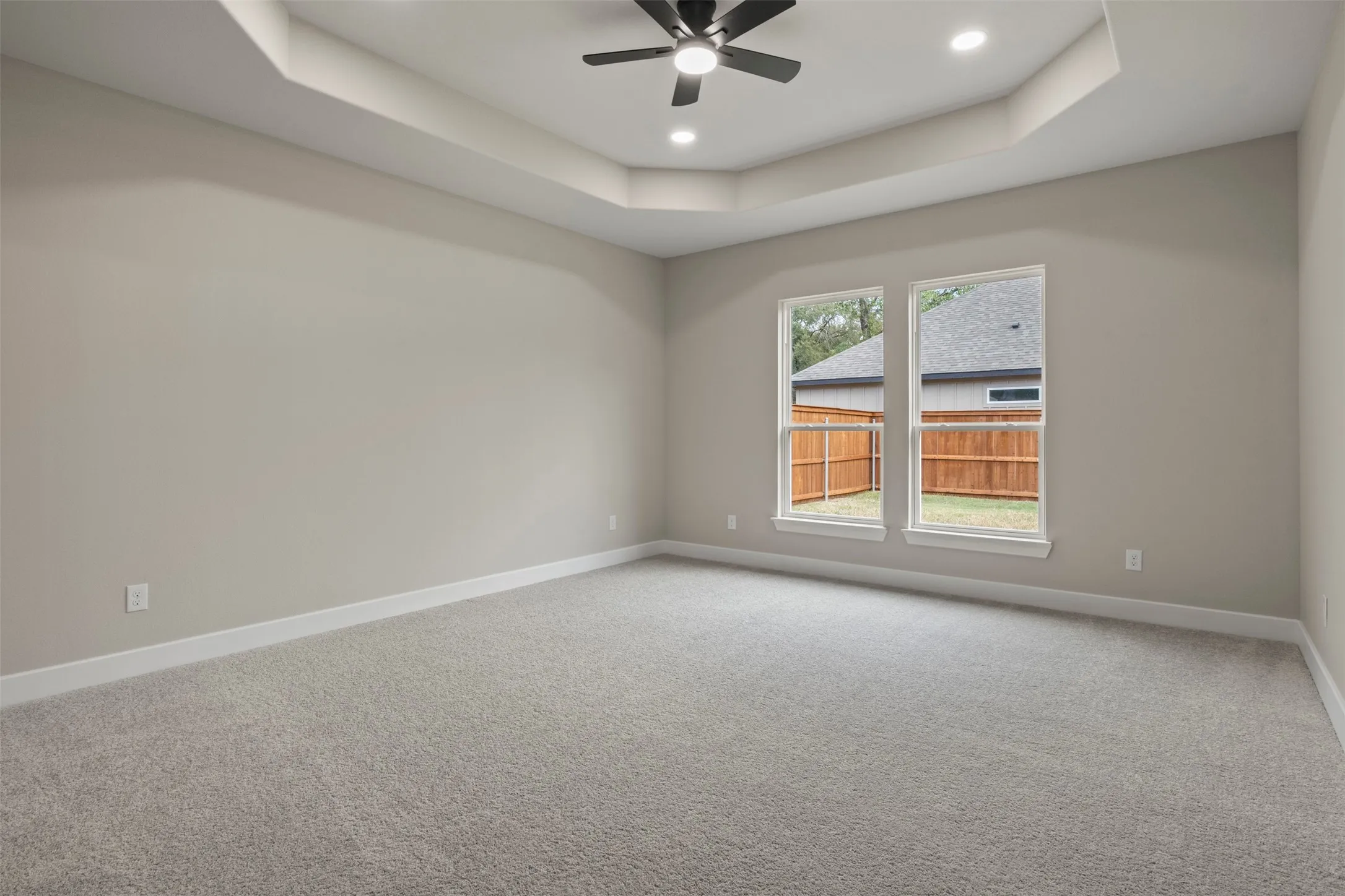 Expansive room with neutral carpet flooring and light-toned walls