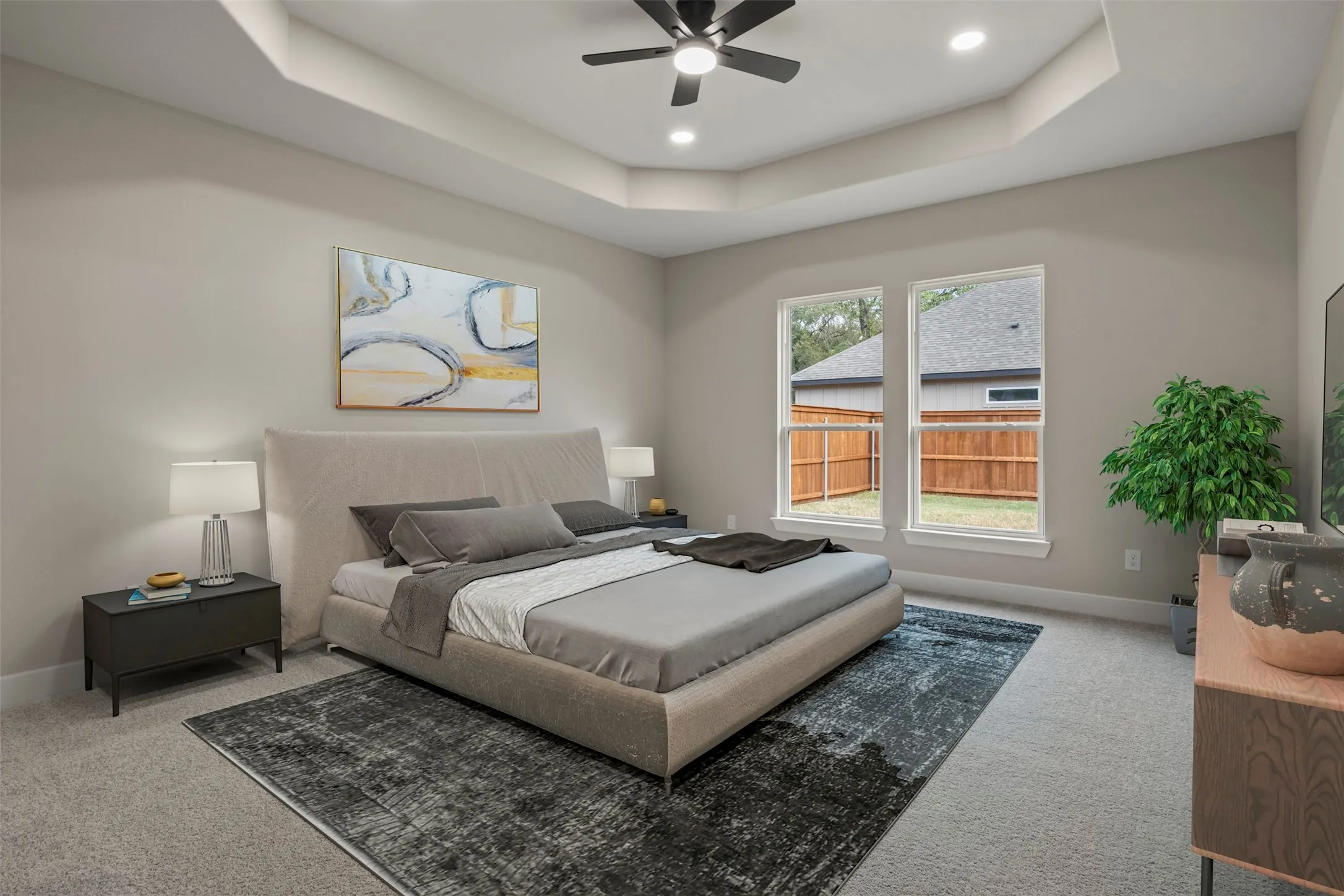 Recessed lighting, ceiling fan, two windows, and tray ceiling