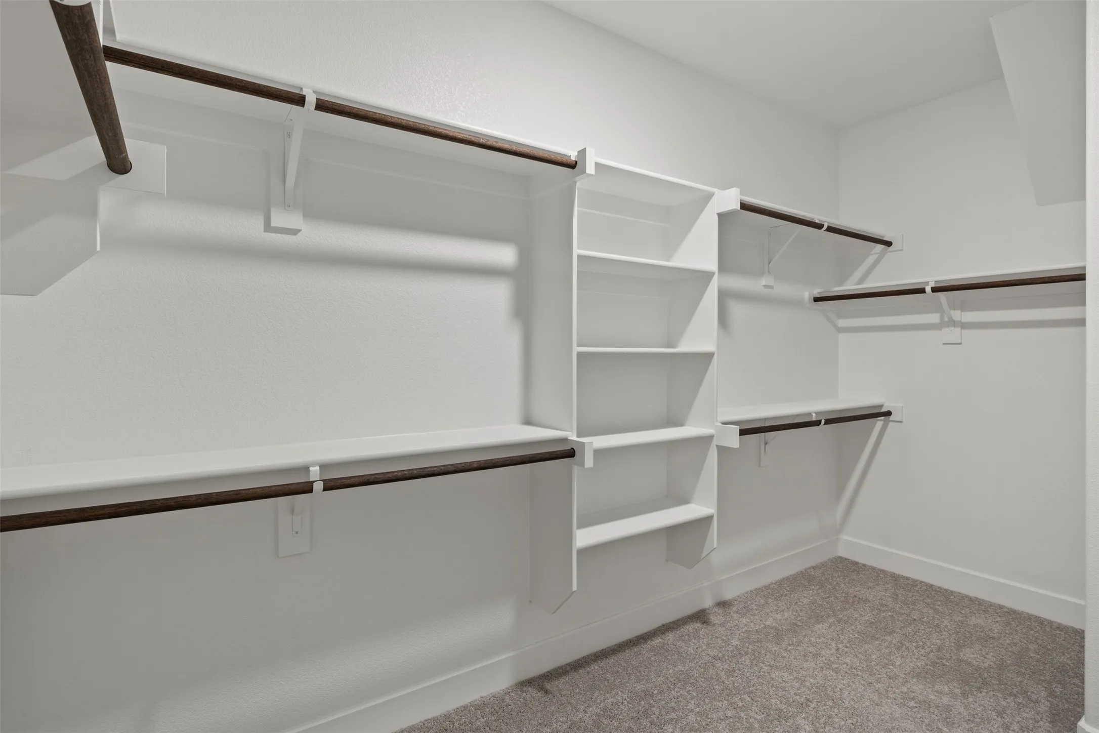 Organized closet with multiple shelving units and hanging rods