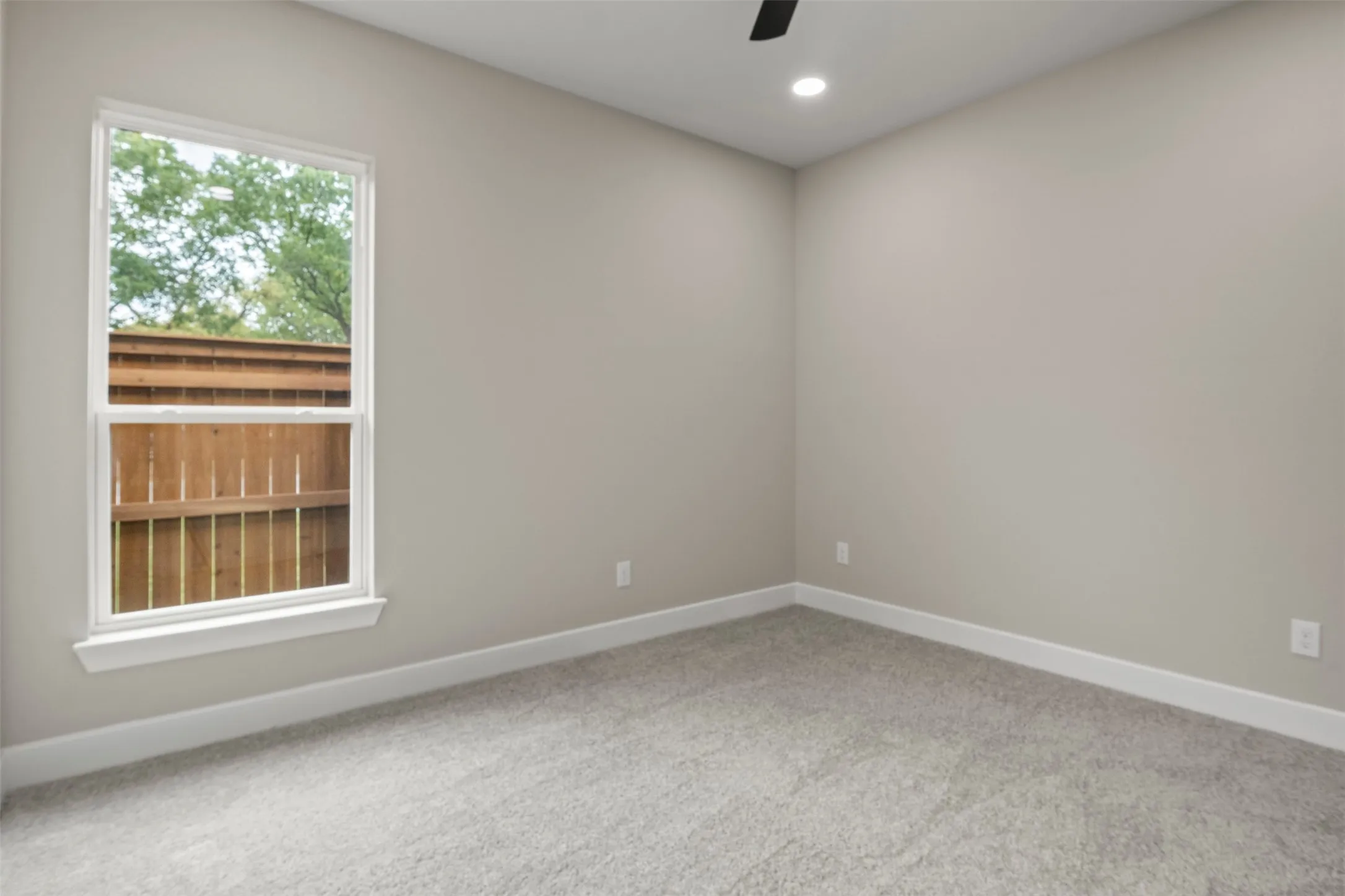 Neutral wall paint, plush carpeting, white trim, recessed lighting, and a ceiling fan