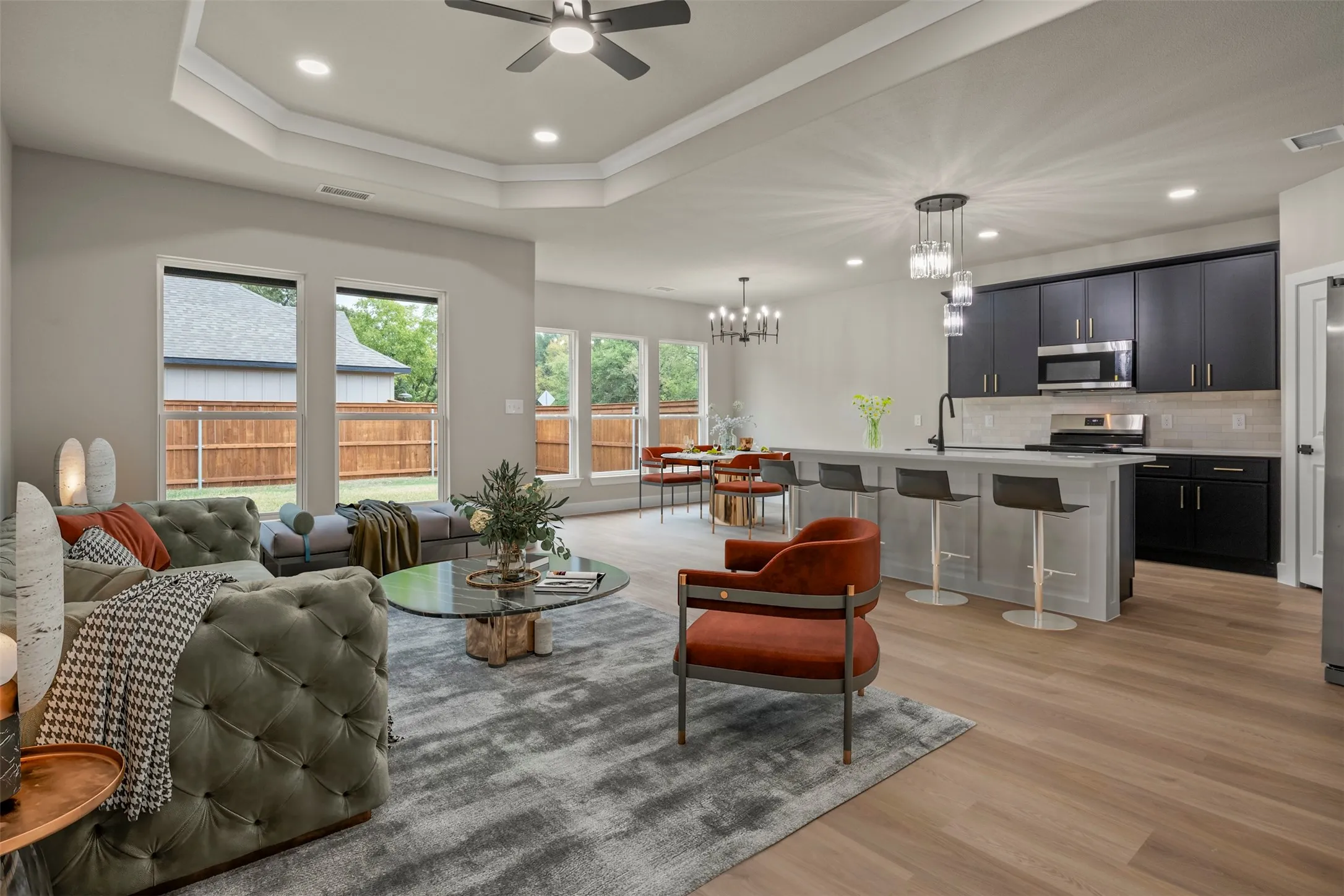 Open-concept living space featuring wood-finish flooring, a coffered ceiling, and recessed lighting