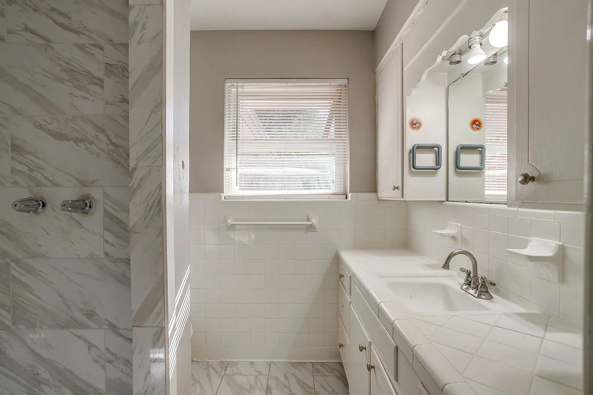 Vanity with dual integrated sinks, white tile countertop, and medicine cabinet with mirror