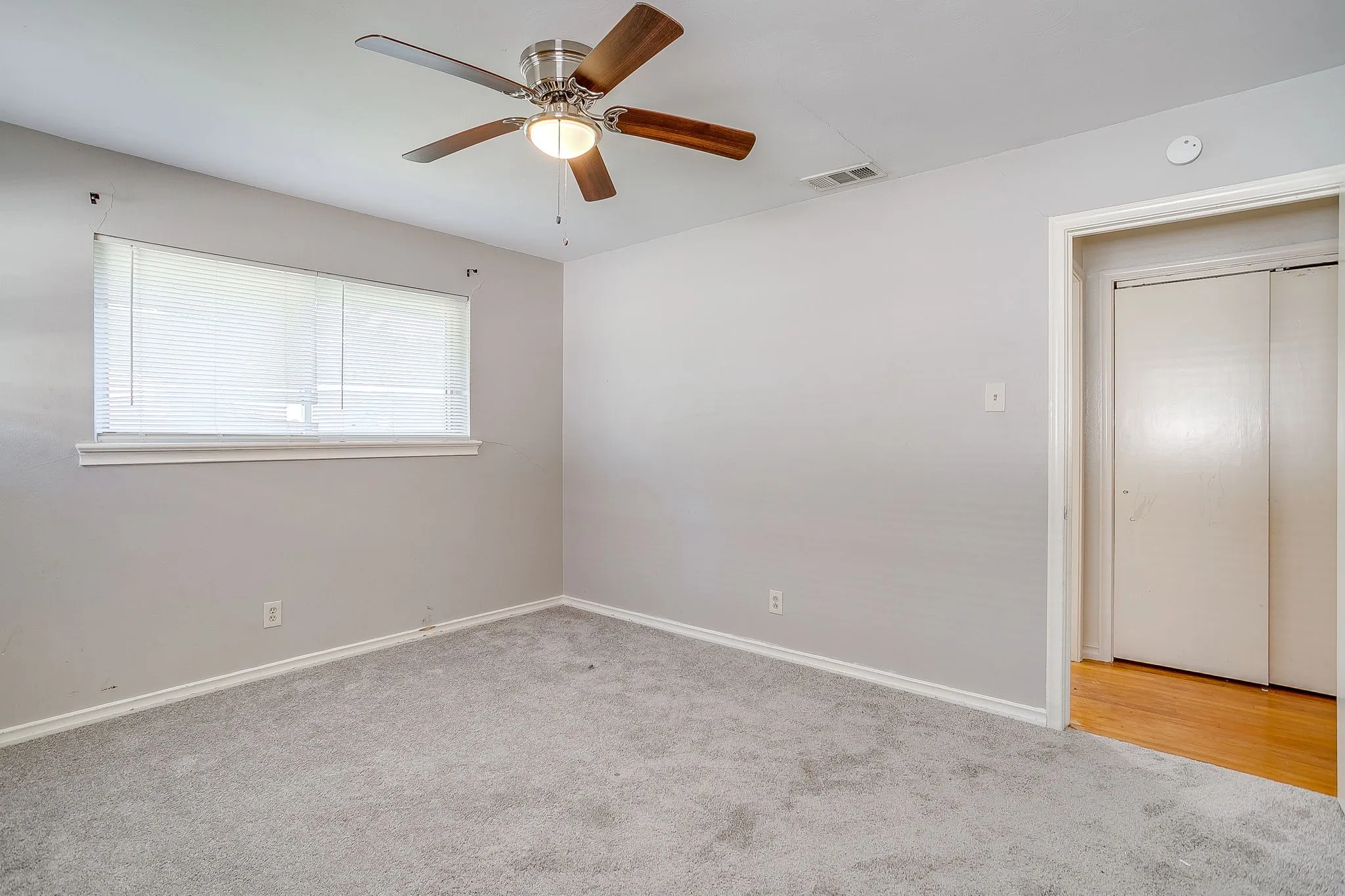 Guest bedroom #1 Carpeted flooring with painted walls, a ceiling fan with light fixture, and a window with blinds