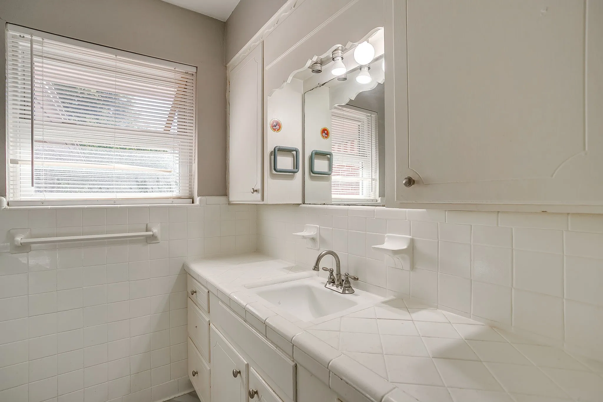 Bathroom vanity with an integrated sink, tile countertop, and matching tile backsplash