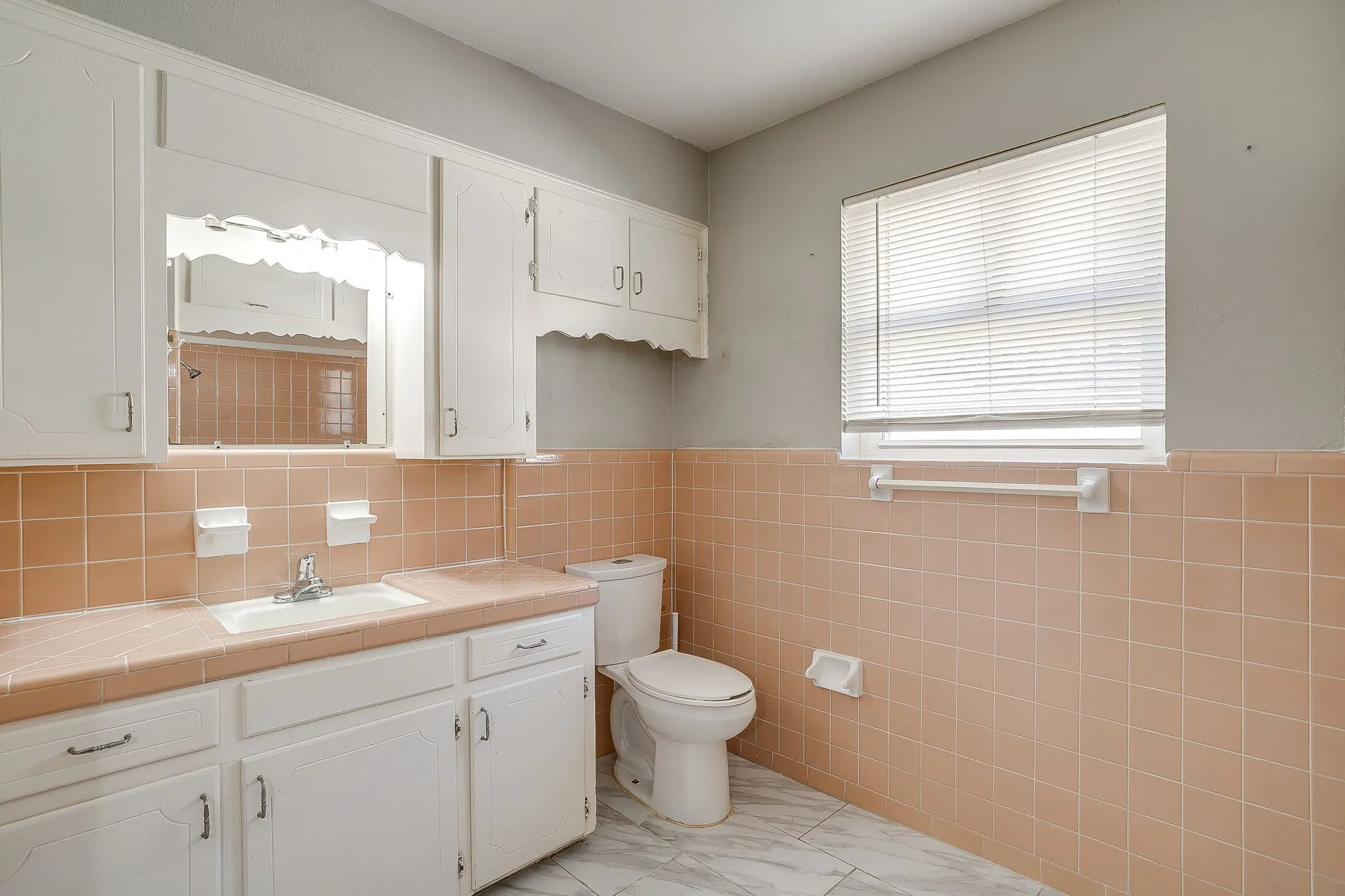 Large Guest bathroom White vanity cabinetry with integrated sink, chrome faucet, and tiled countertop