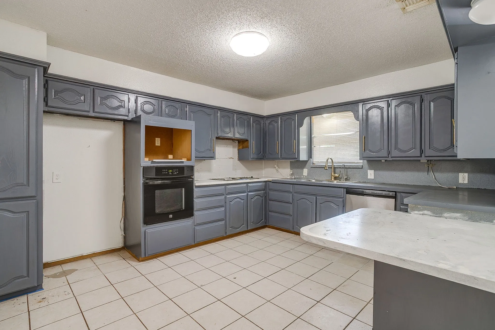 Kitchen with built-in oven, extensive cabinetry, and tile flooring