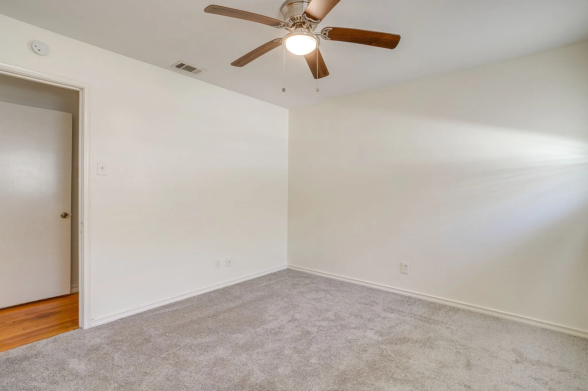 Guest bedroom #2 Neutral wall paint, ceiling fan with integrated lighting, and plush carpet flooring