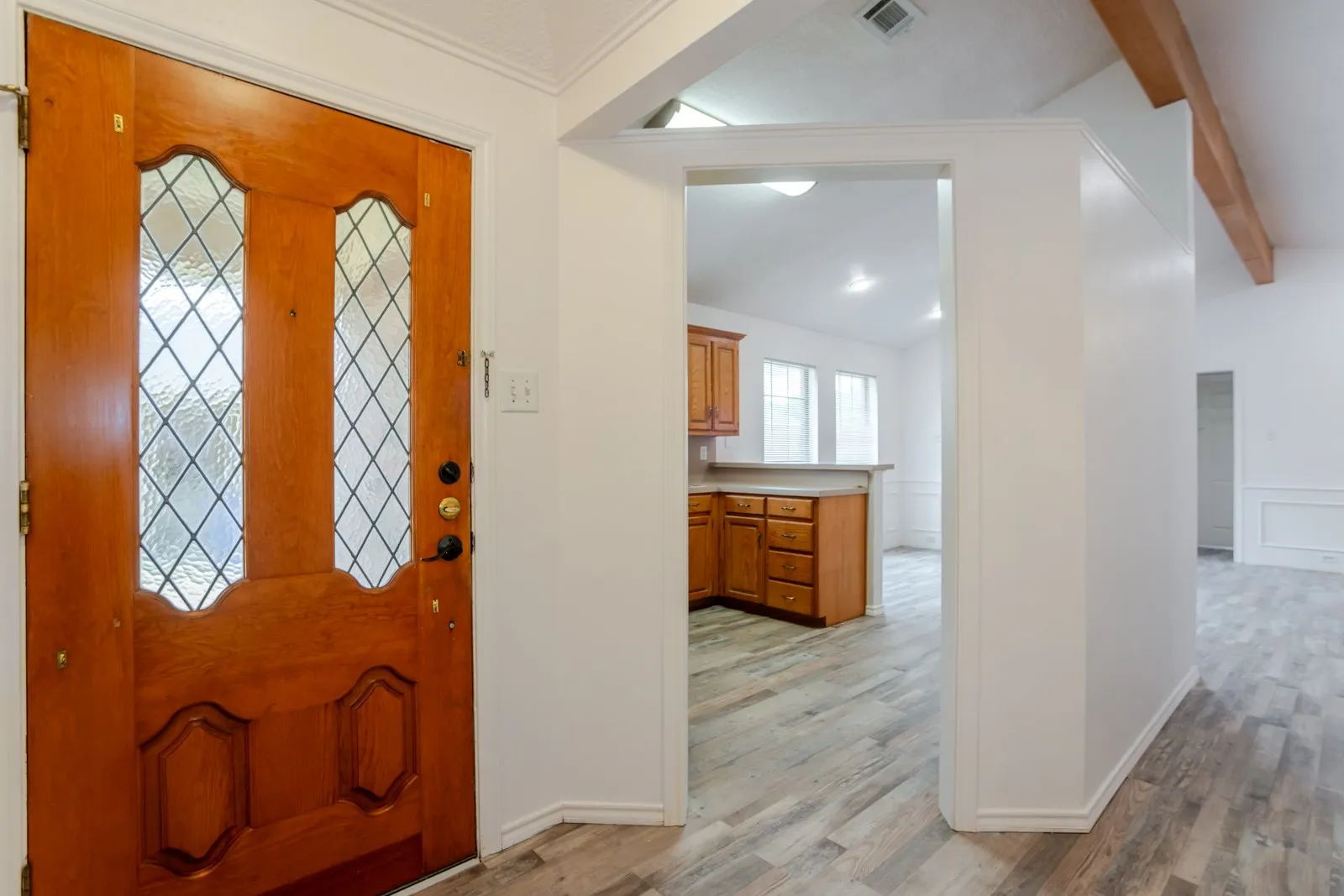 Entryway featuring a wood door with leaded glass, wood-finish flooring, and crown molding