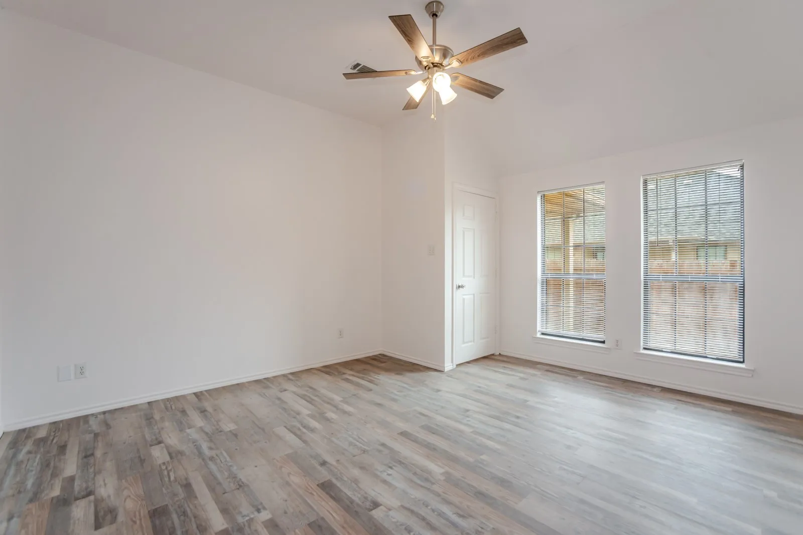 Wood-finish flooring throughout, vaulted ceiling, and two windows with blinds