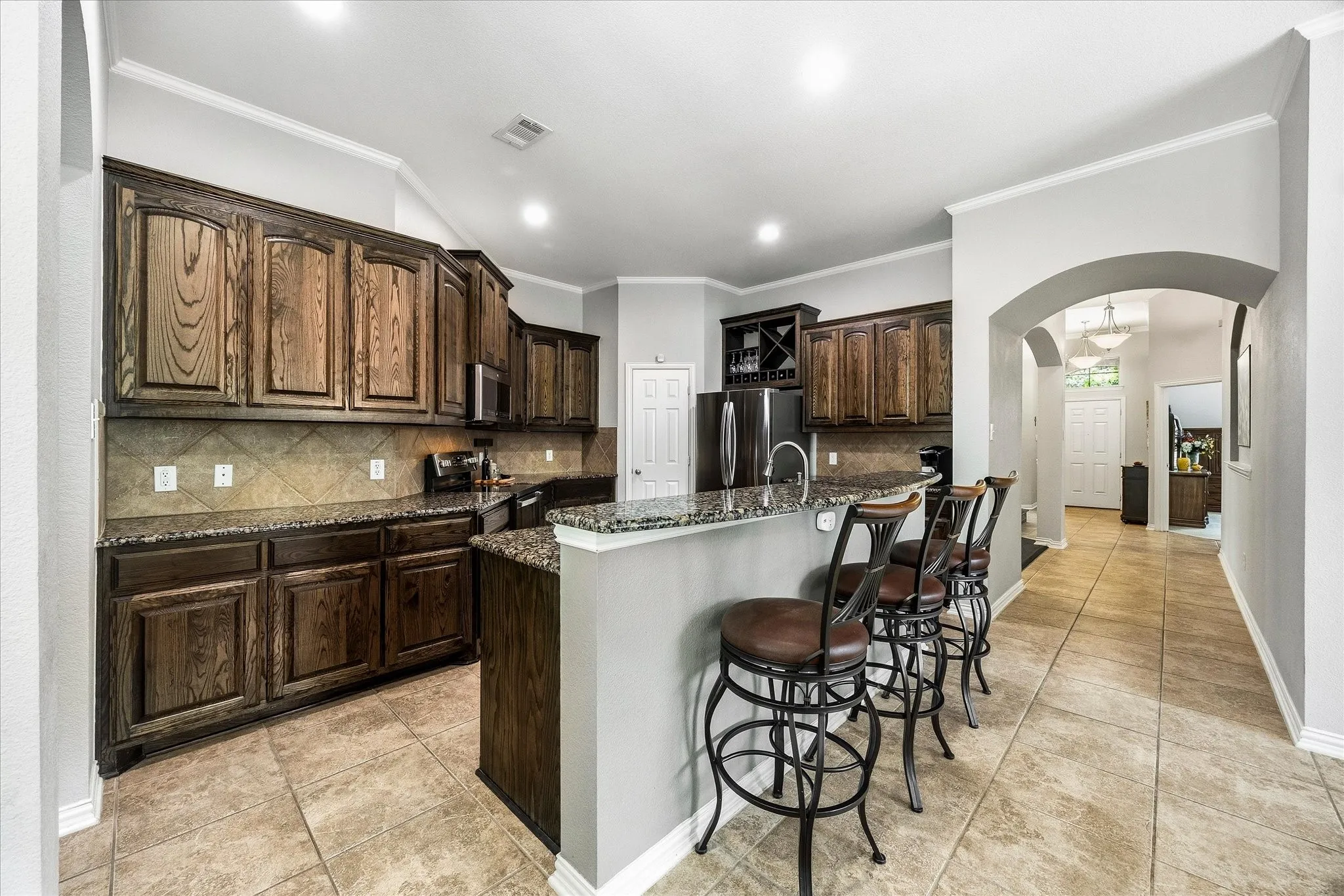 Kitchen includes tons of cabinetry, granite countertops, roomy pantry and stainless steel appliances.