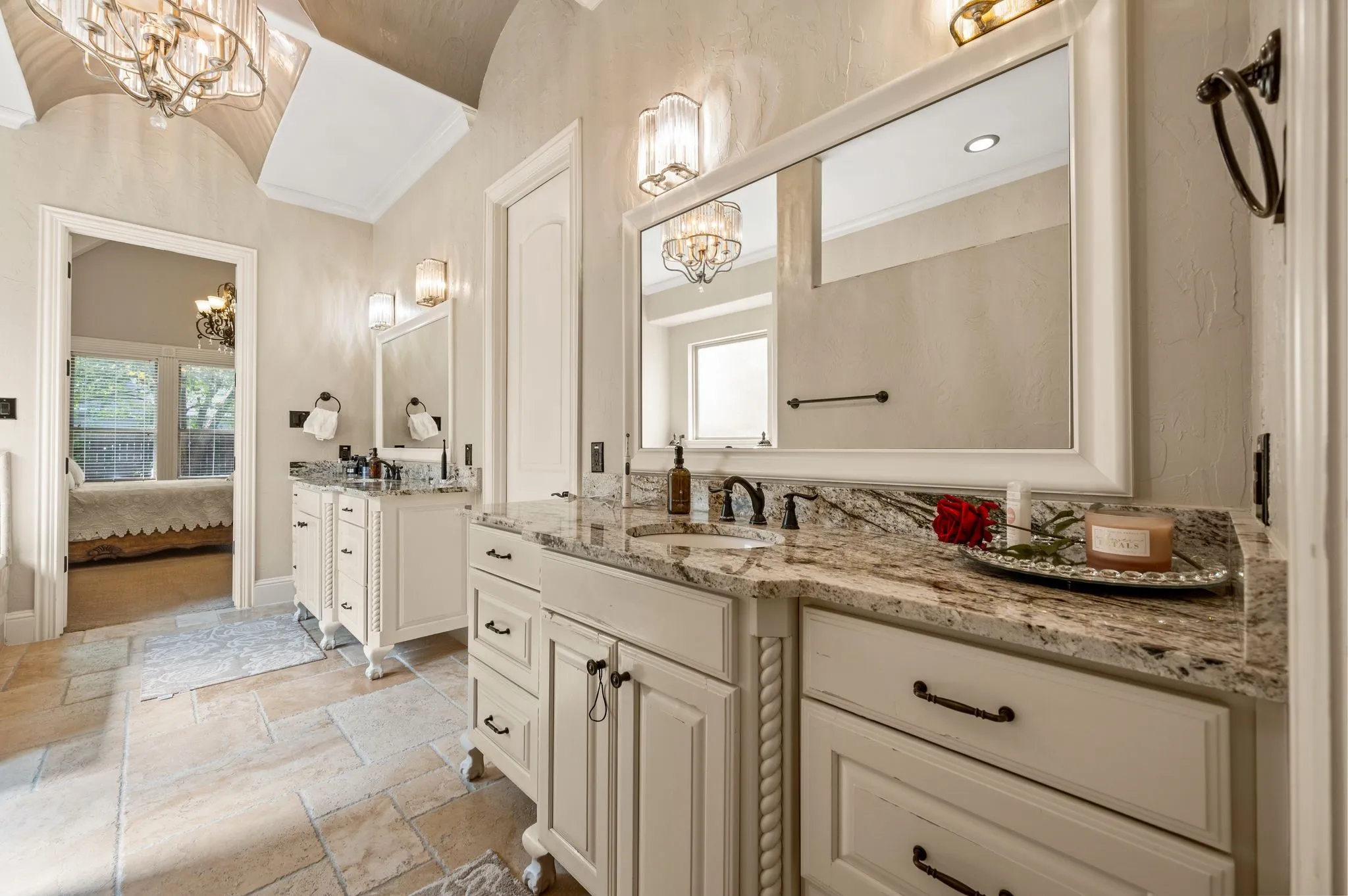 Dual vanity with granite countertops, light wood-finish cabinetry, and framed mirrors