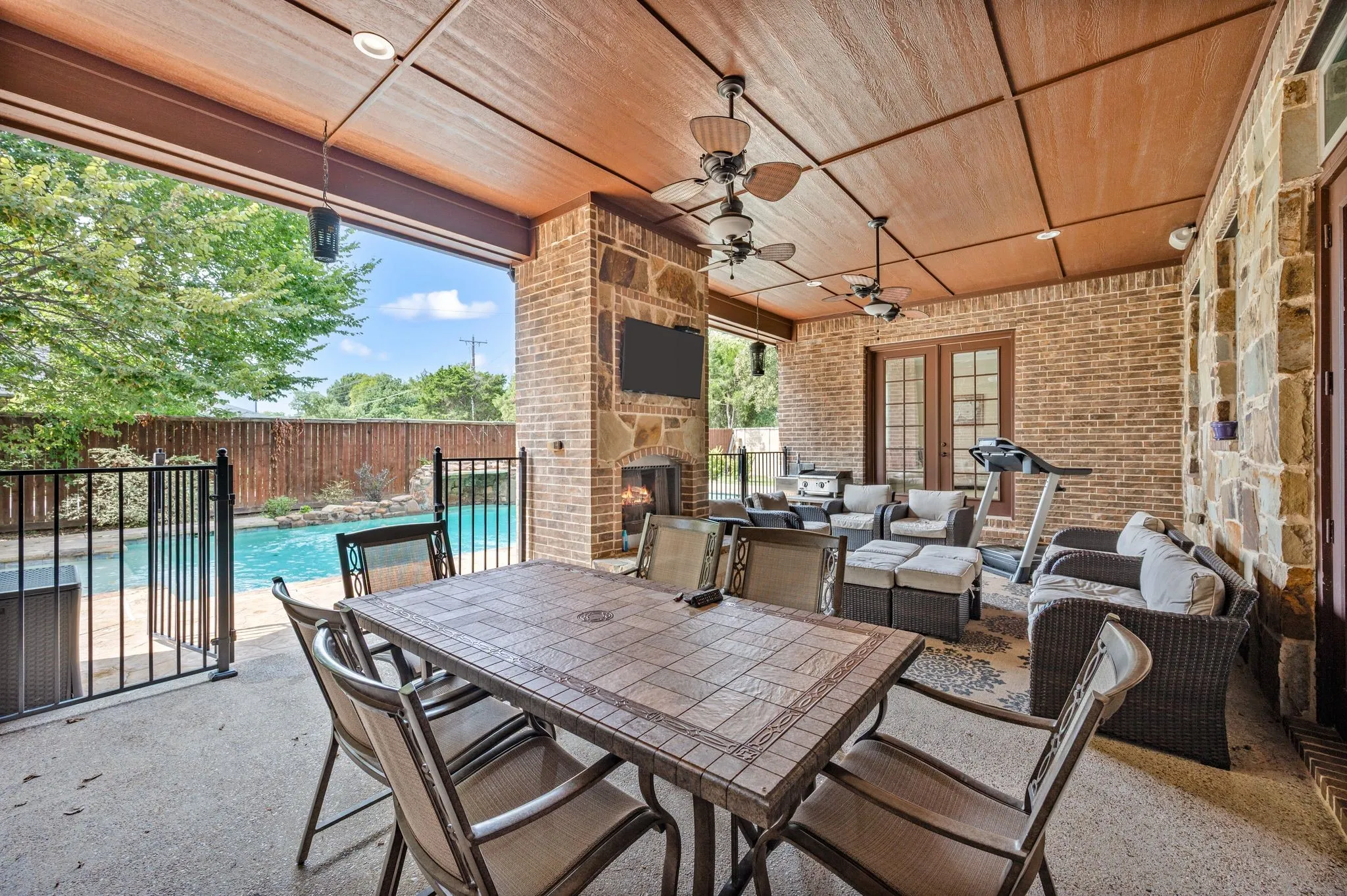 Covered patio featuring a wood-finish ceiling with recessed lighting and ceiling fans