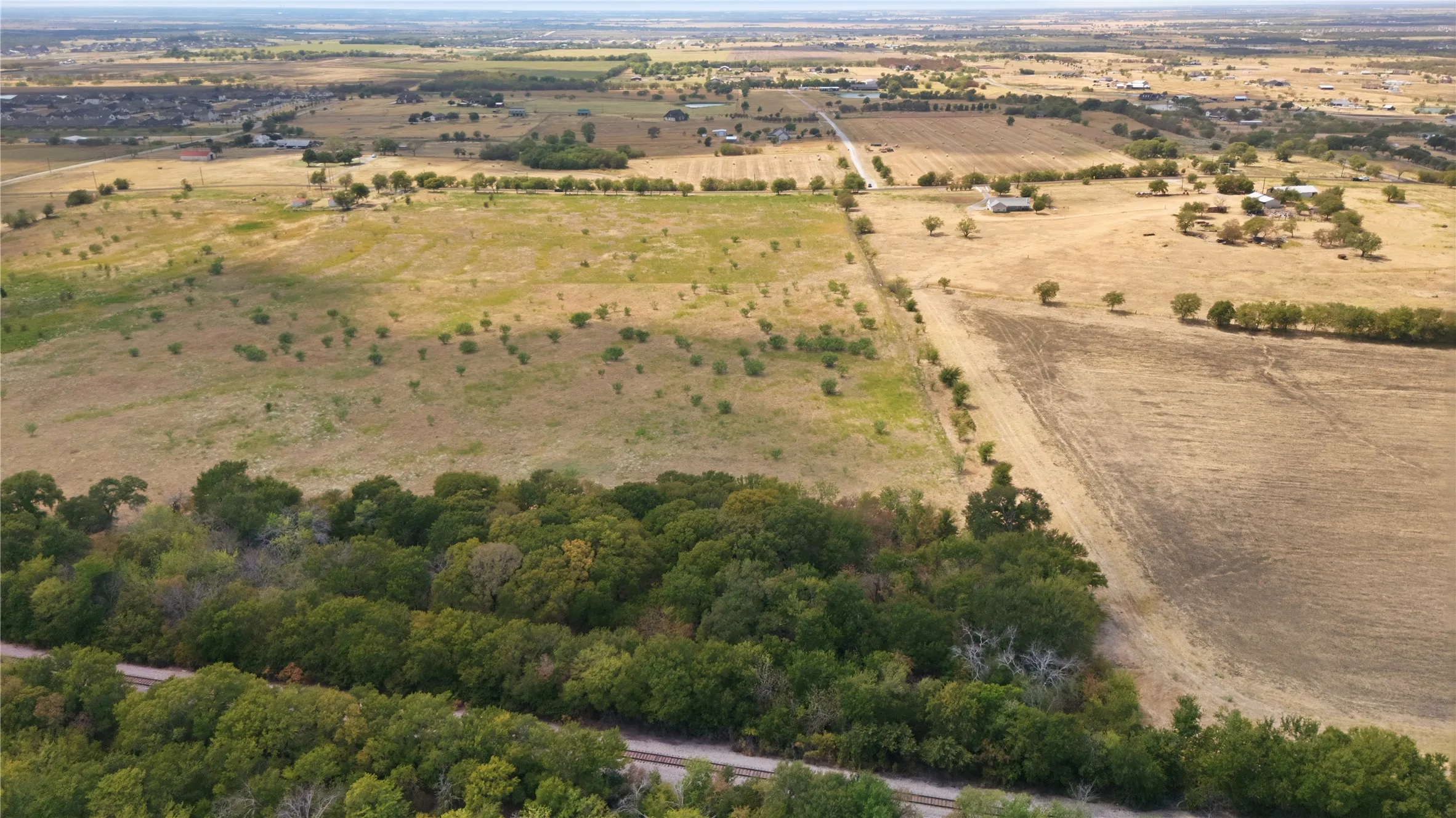 Expansive land offering diverse topography, including wooded areas and open fields