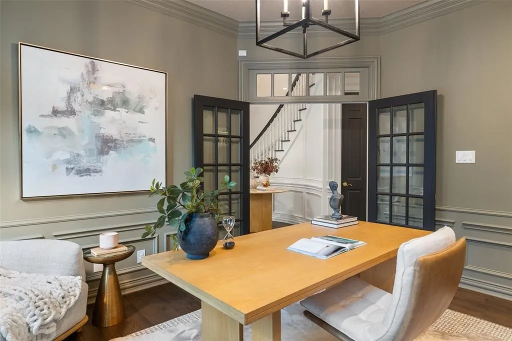 Room with wood-finish flooring, wainscoting, and crown molding
