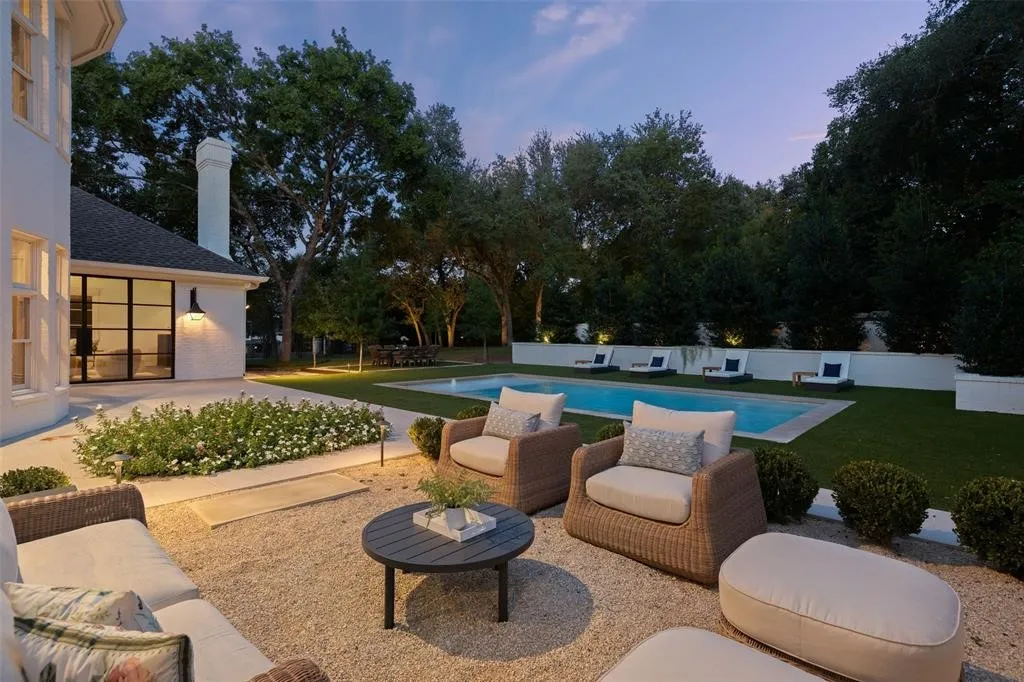 Exterior patio with gravel surfacing, an in-ground swimming pool, and manicured landscaping