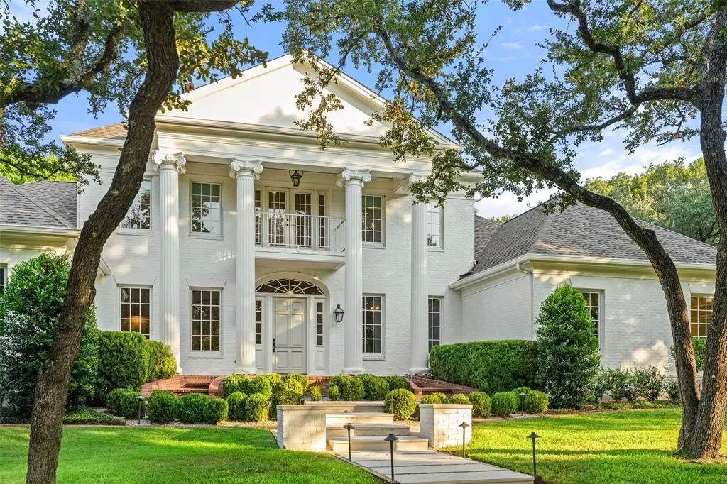 Grand white brick exterior with stately columns and a second-story balcony