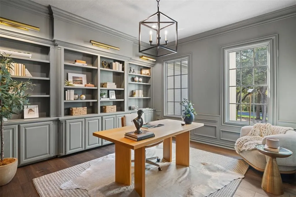 Built-in gray cabinetry with open shelving, wood-finish flooring, full-height windows, wall sconces, and a geometric chandelier