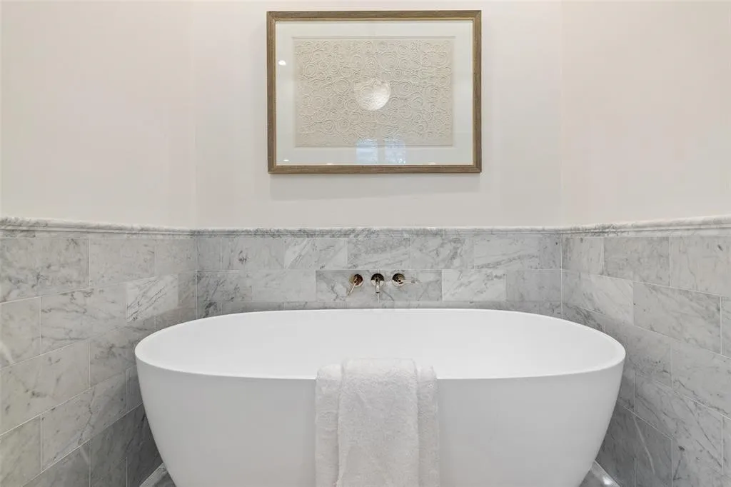 Freestanding soaking tub with wall-mounted fixtures