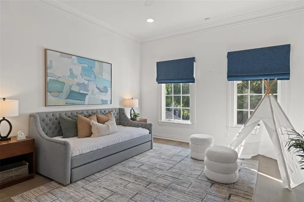 Bright room featuring two large windows with blue Roman shades, crown molding, and wood-finish flooring