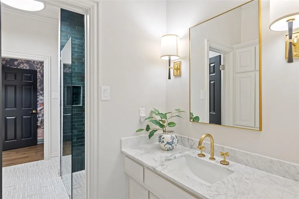 White vanity with a stone countertop and an undermount sink