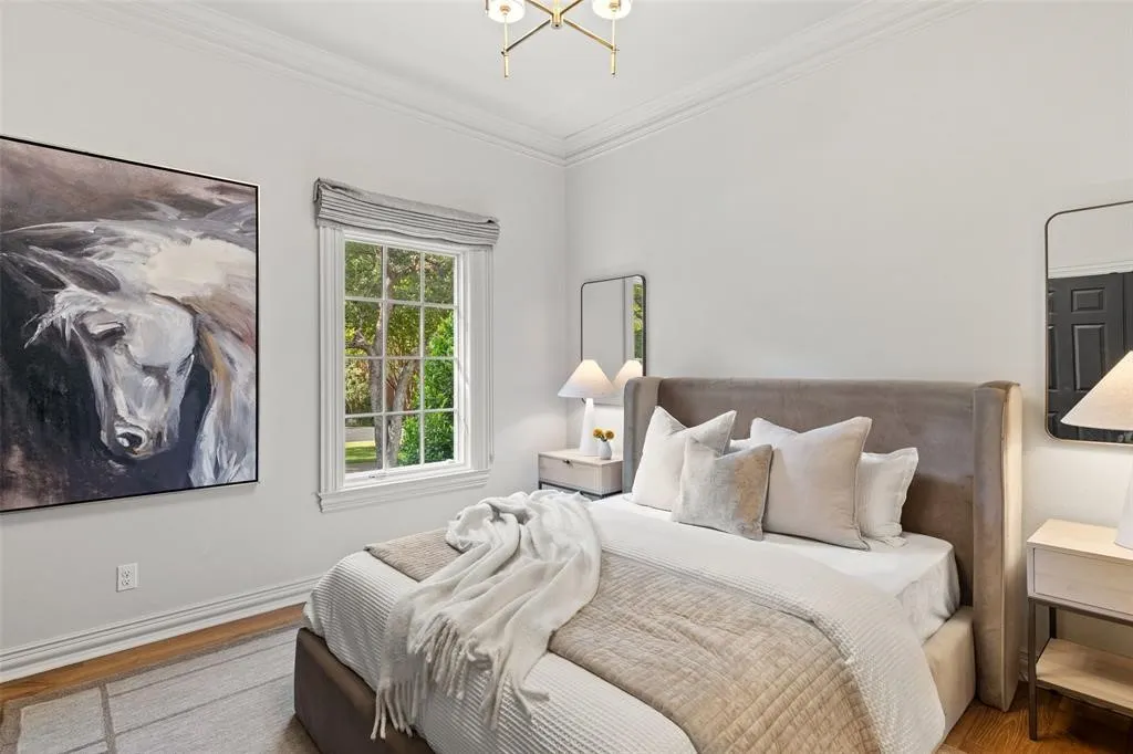 Wood-finish flooring, crown molding, and a window with exterior tree scenery