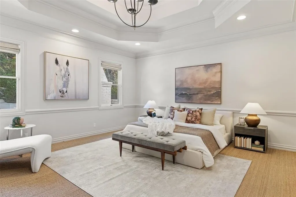Recessed lighting illuminates a coffered ceiling, complemented by a central chandelier