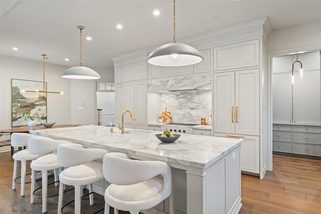 Expansive kitchen island with a stone countertop, built-in cabinetry, and a gold-finish faucet