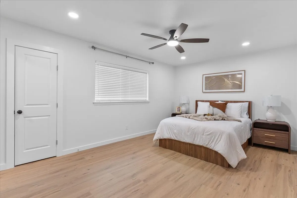 Recessed lighting, wood-finish flooring, white walls, ceiling fan, and a window with horizontal blinds