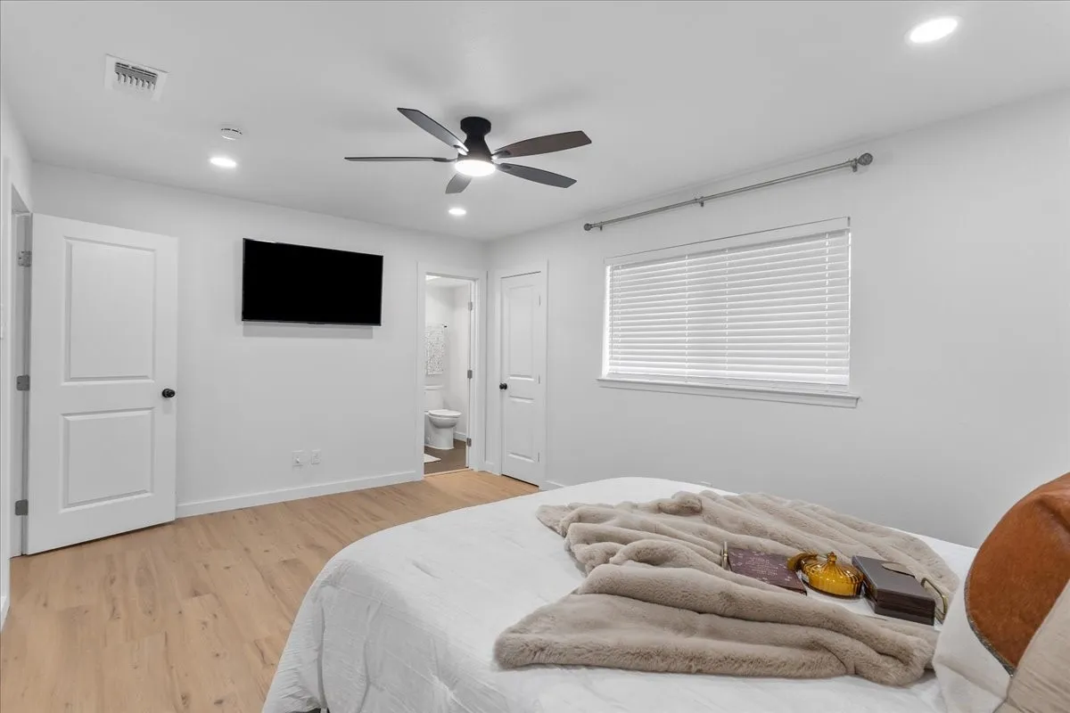 Recessed lighting, wood-finish flooring, white paneled doors, ceiling fan with light, and a window with horizontal blinds