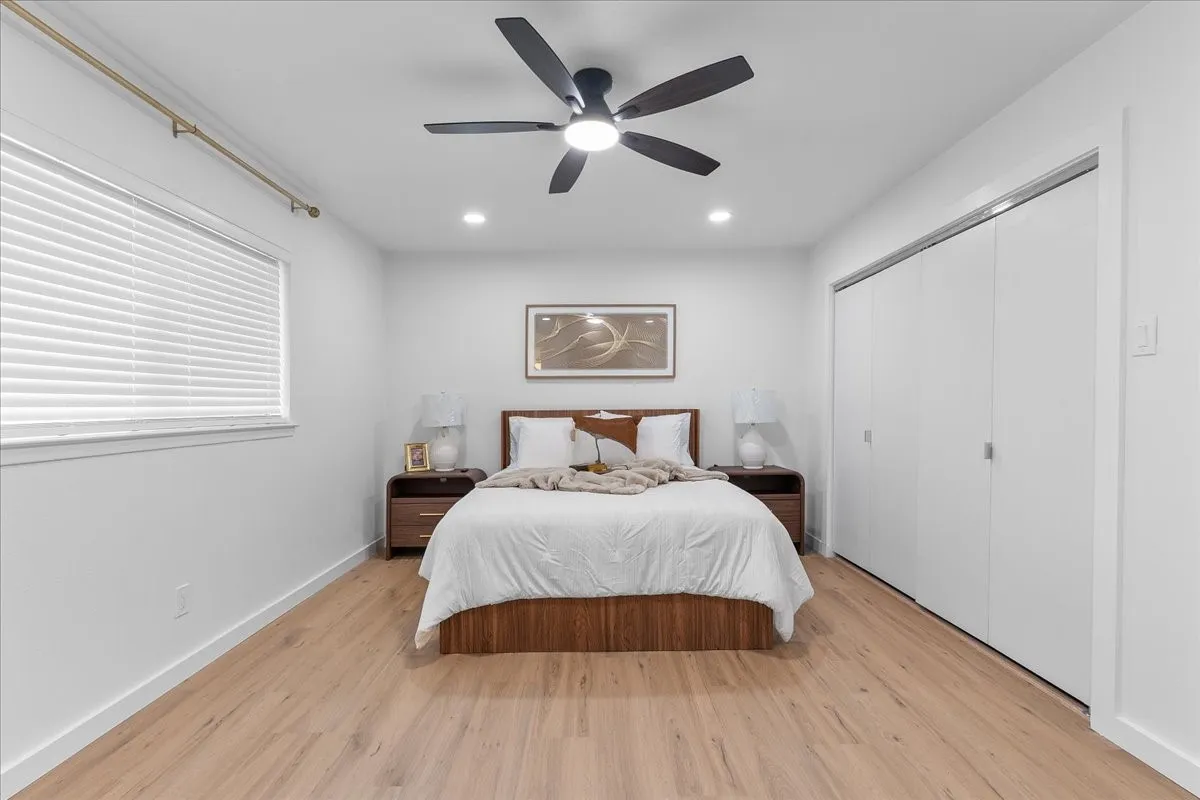 Recessed lighting, ceiling fan, wood-finish flooring, white window blinds, and built-in closet doors