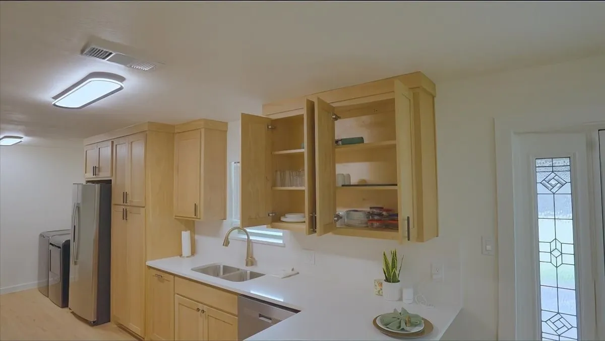 Light wood-finish cabinetry, stainless steel appliances, and a double basin sink
